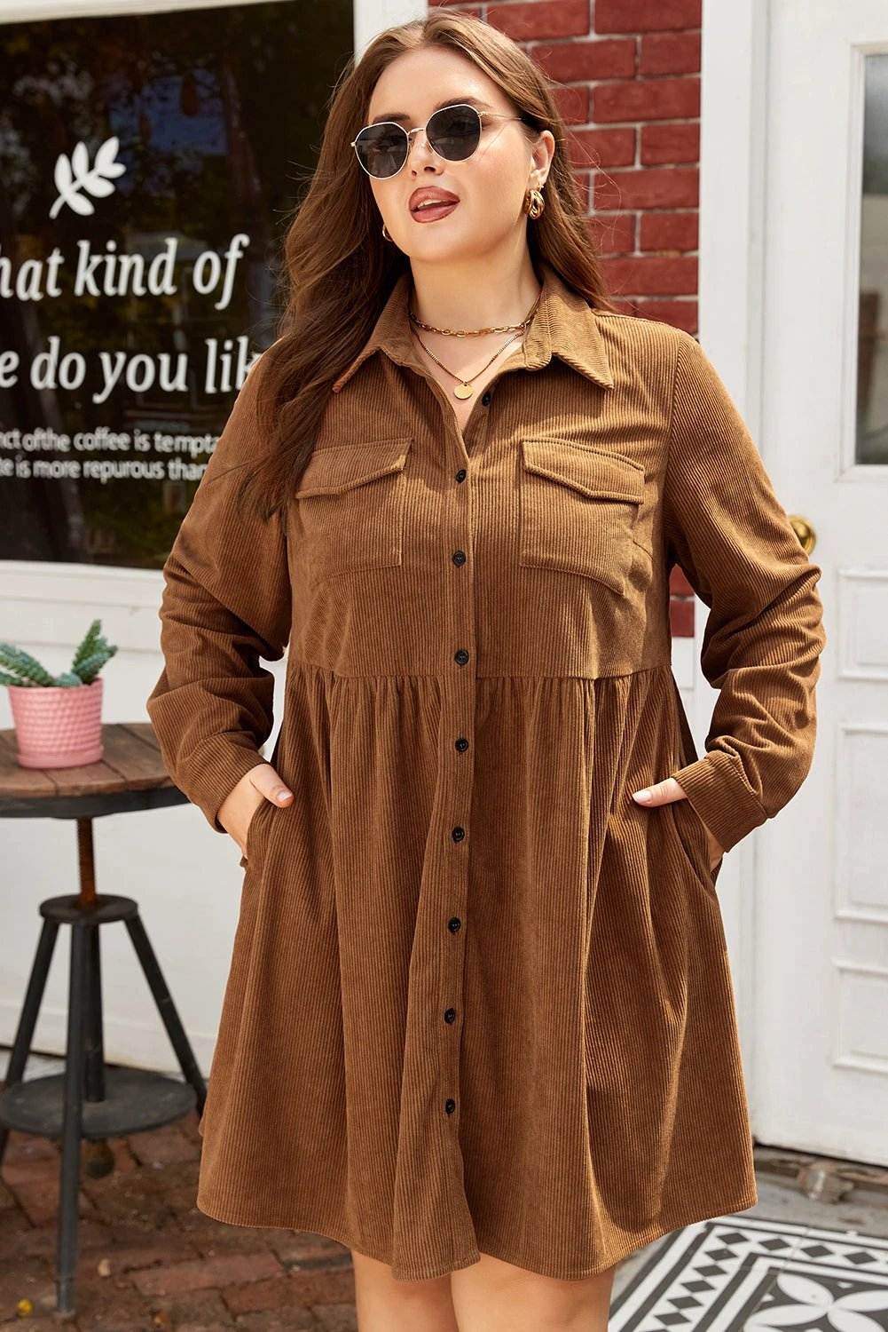 Plus size brown corduroy button-front shirt dress with collar and chest pockets on model