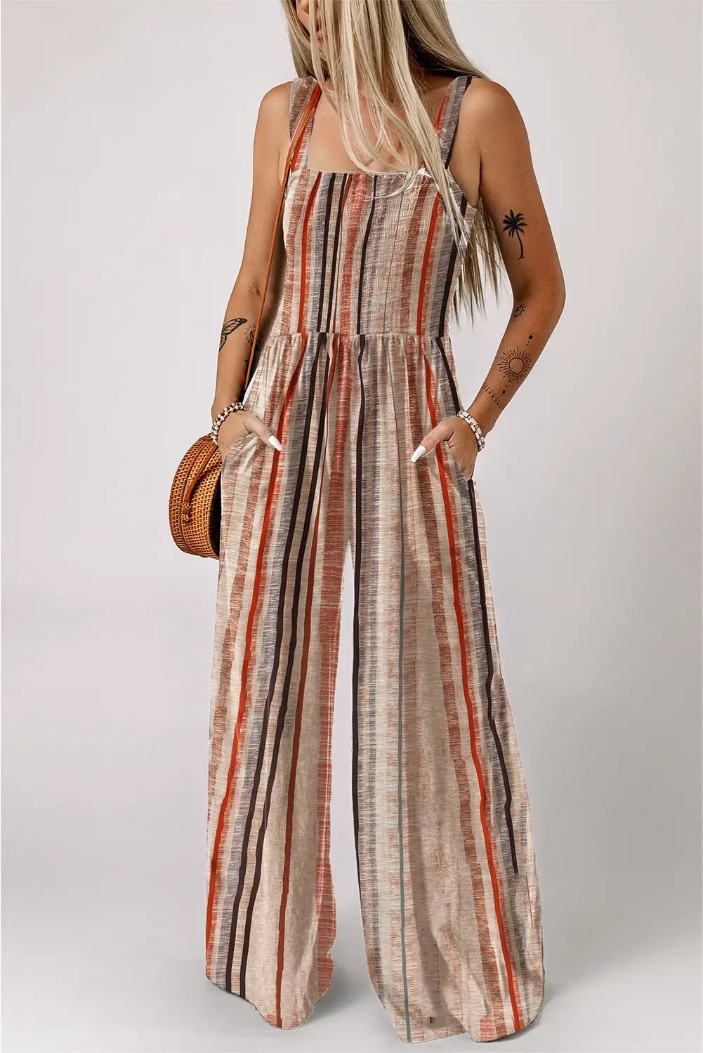 Woman wearing yellow stripe smocked square neck jumpsuit with wide leg outdoors