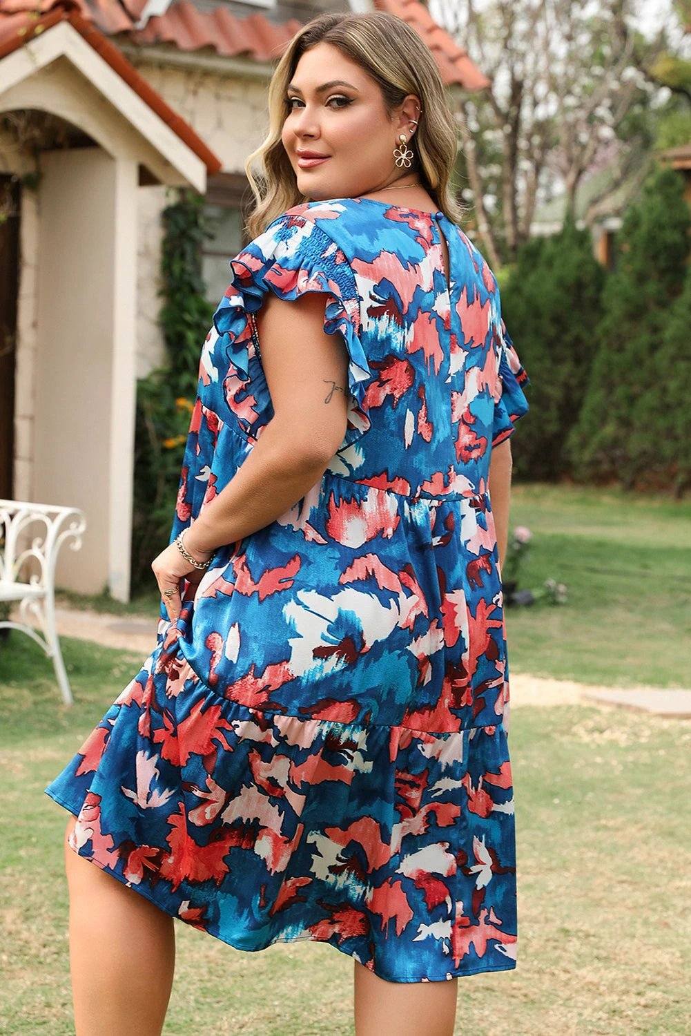 Plus size abstract print dress with shirred bodice, ruffled sleeves, and tiered mini skirt