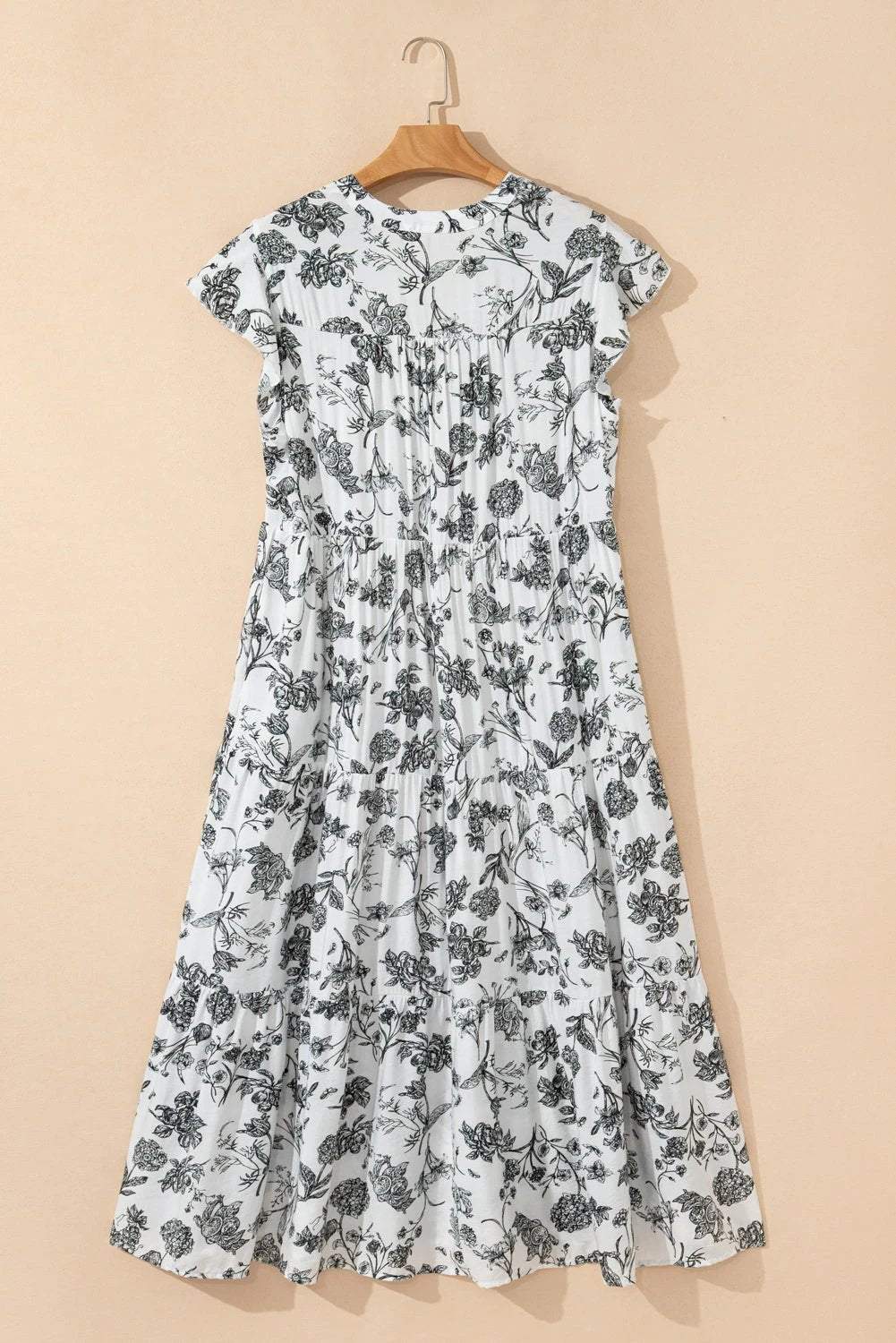Plus size floral maxi dress with notched neck, piping trim, and ruffle sleeves on model