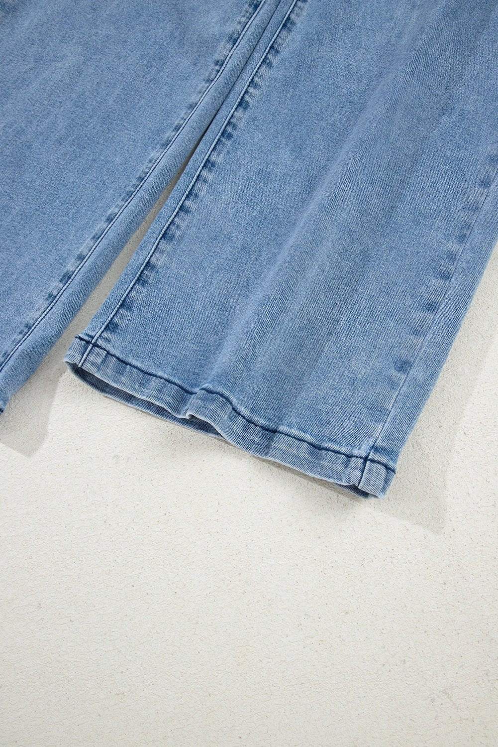 Woman wearing acid washed bow knot sash wide leg jeans standing outdoors
