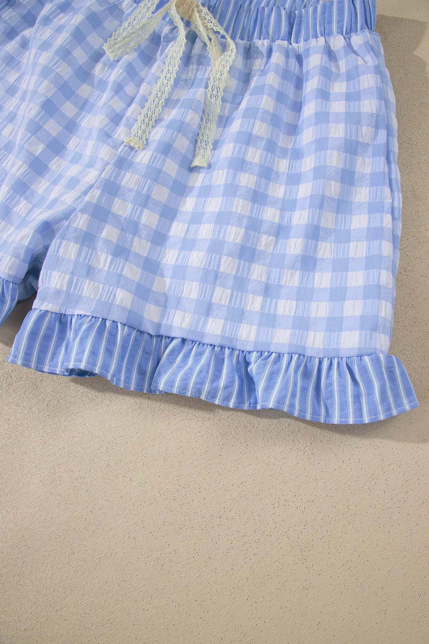 woman wearing gingham ruffle hem shorts with lace tie waist in casual outdoor setting