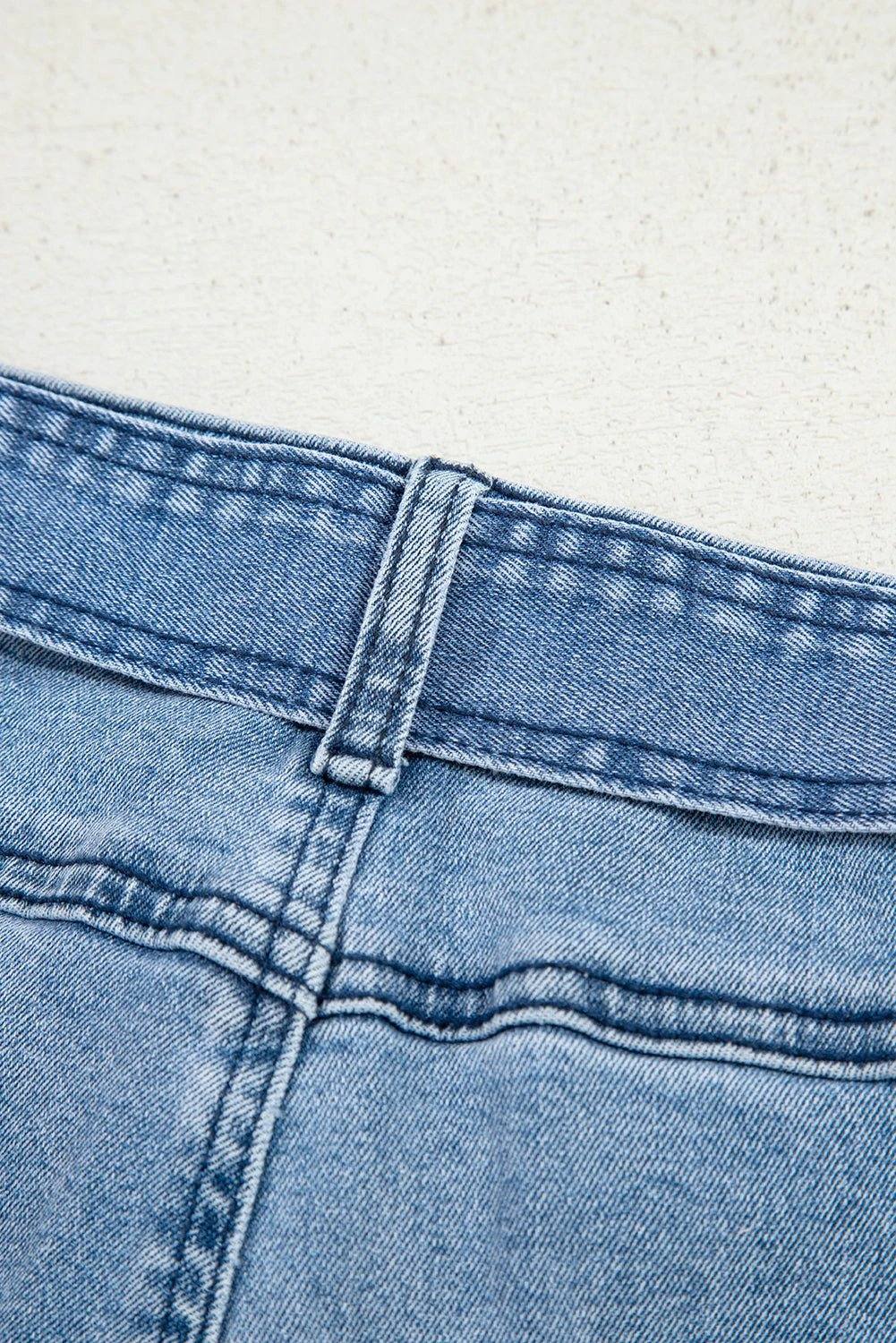 Woman wearing acid washed bow knot sash wide leg jeans standing against white background