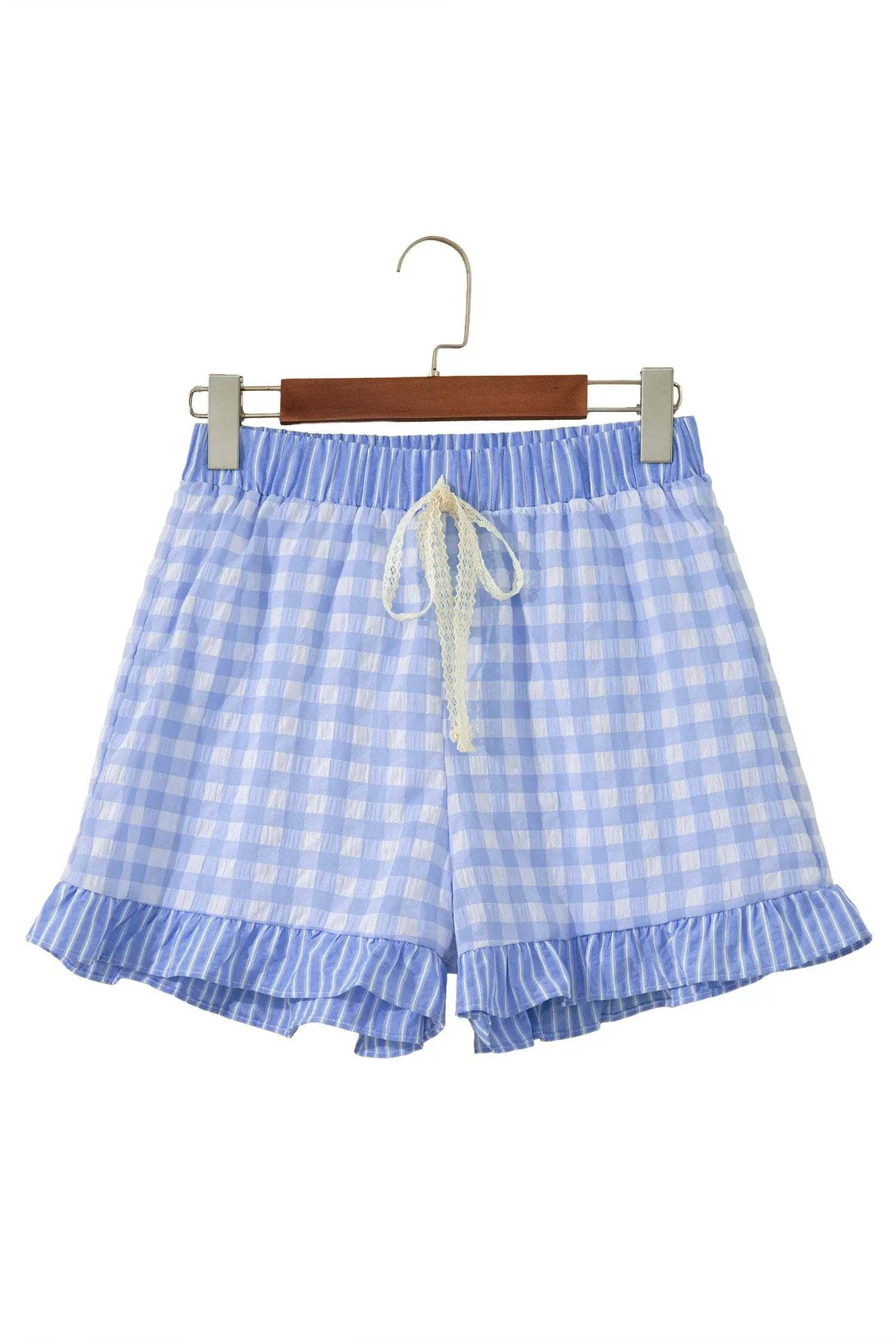 Woman wearing gingham ruffle hem shorts with lace tie waist outdoors on a sunny day