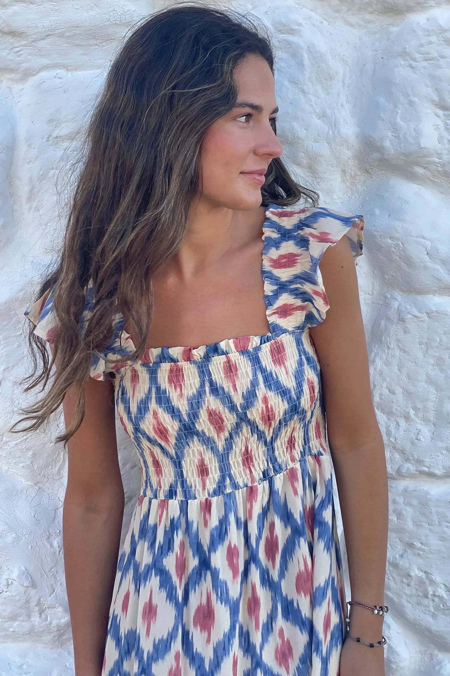 Woman wearing blue geometric print Boho Vacation Vibes dress with square neck and ruffle sleeves outdoors