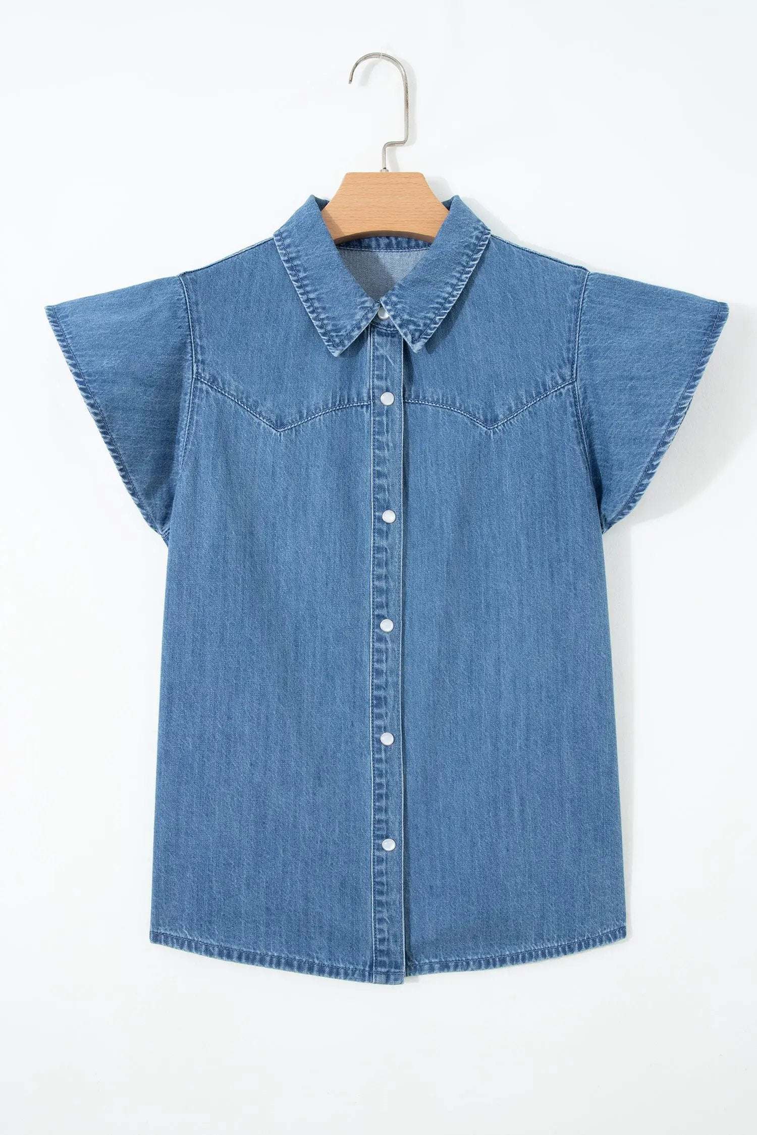 Woman wearing denim ruffled short sleeve shirt with button front and flutter sleeves