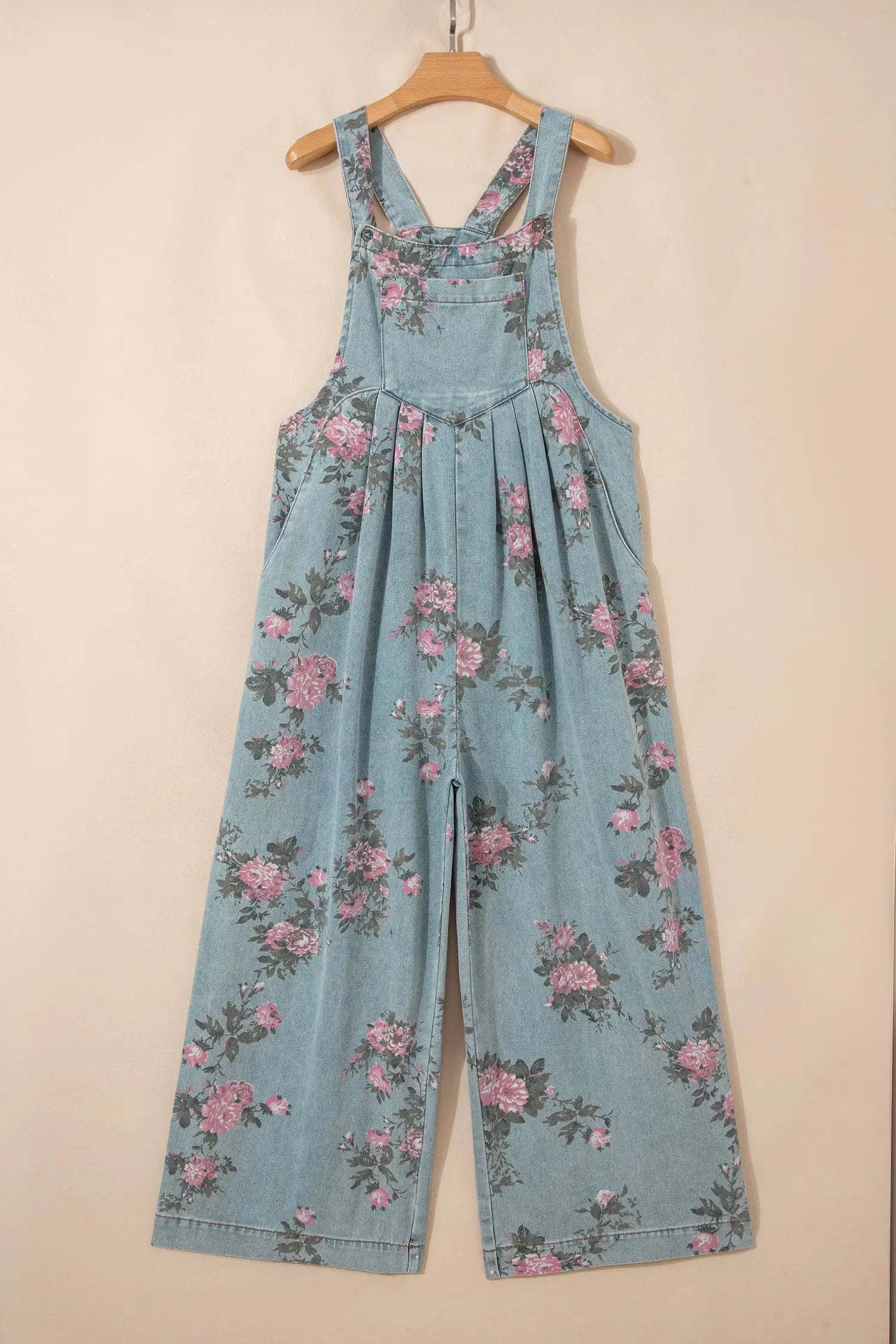 Floral print denim jumpsuit with pleated wide-leg and adjustable straps on model