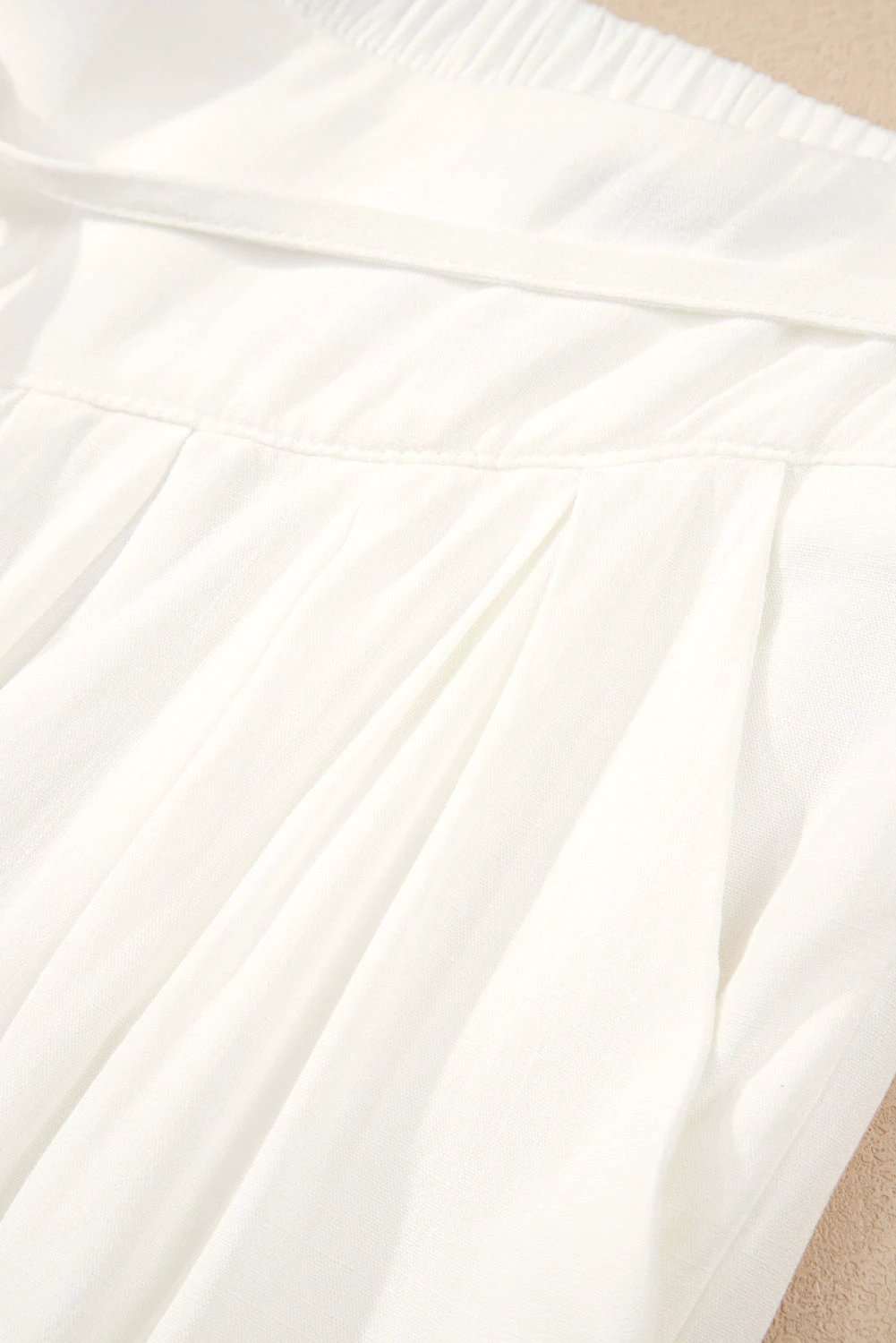 White drop-waist pleated wide-leg cotton-linen pants with adjustable waistband and side pockets