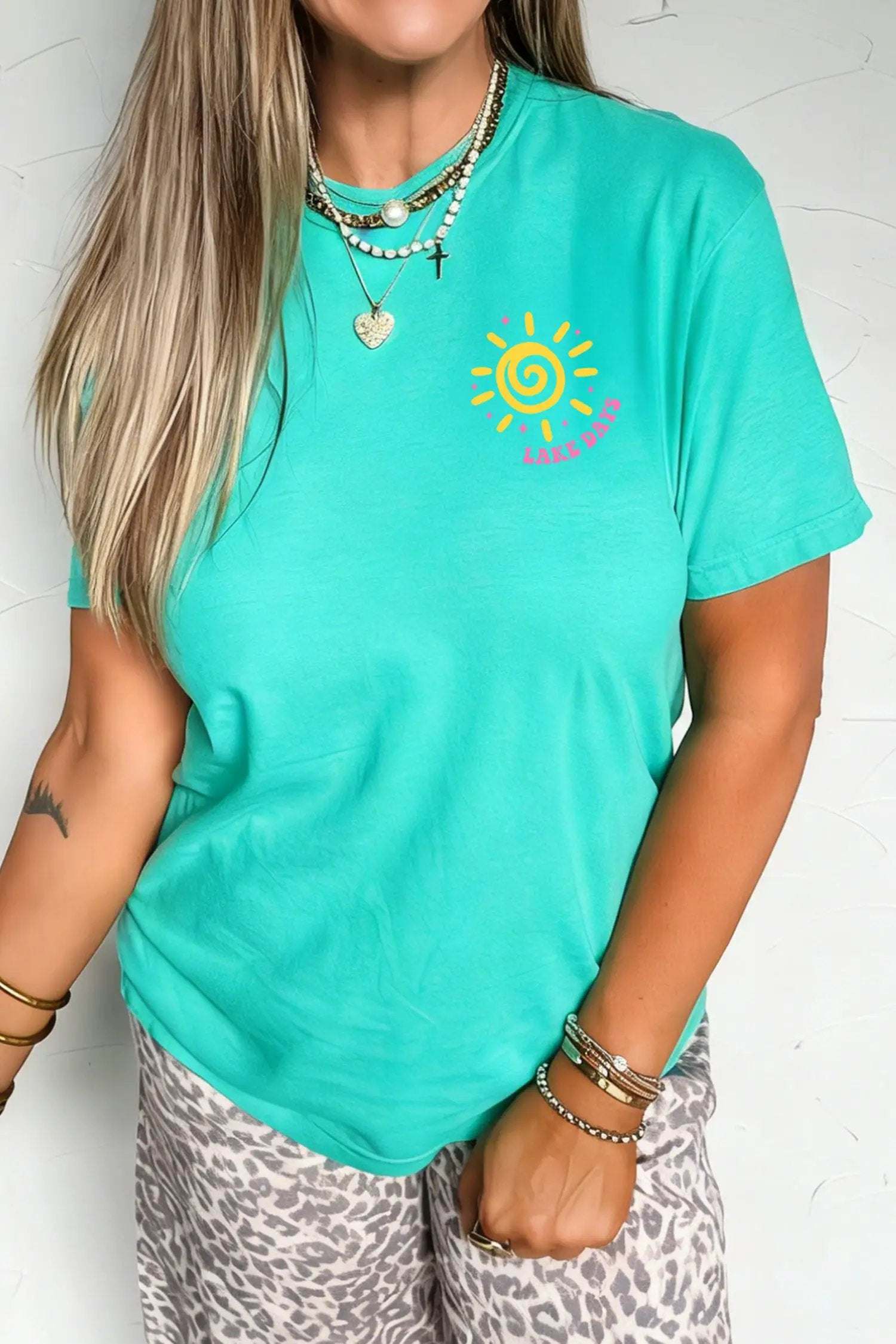 Woman wearing Lake Days double-sided printed graphic tee with relaxed fit by the lake
