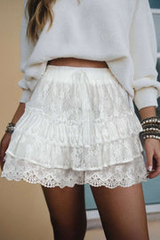 White lace ruffle tiered shorts with drawstring elastic waist and scalloped hem for boho chic style