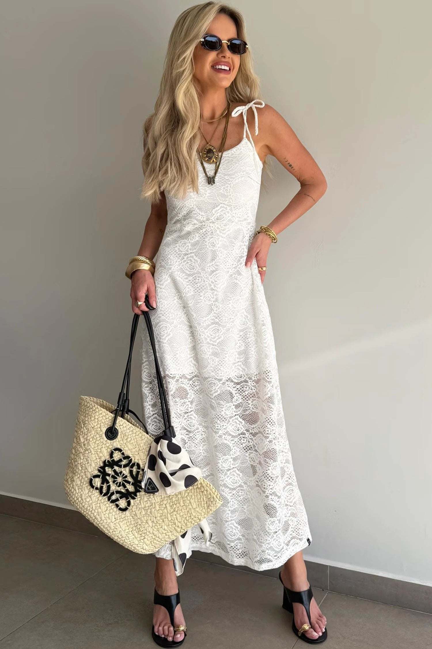 Woman wearing floral lace overlay maxi dress with spaghetti straps outdoors