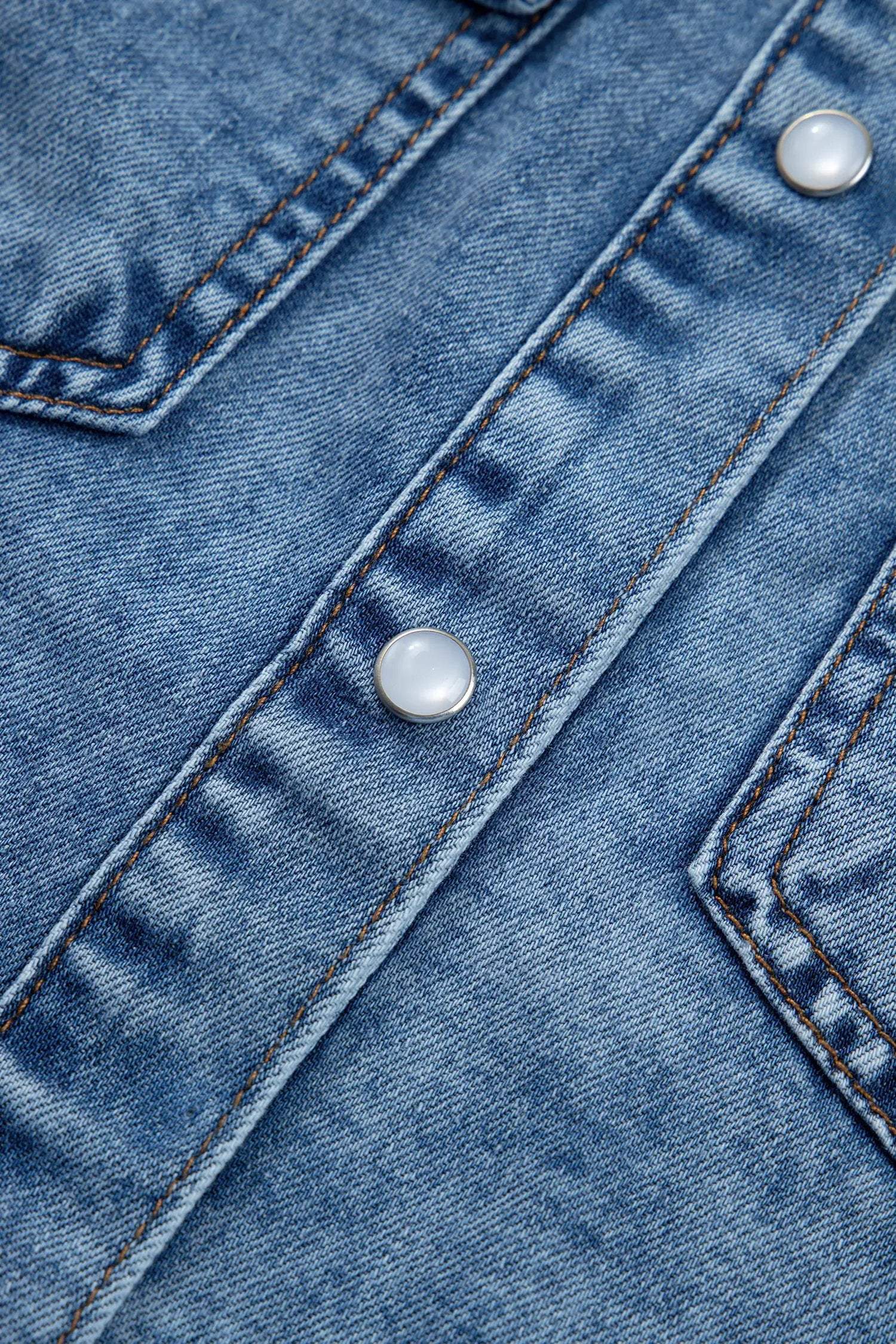 Sleeveless button-front denim top with collar and Western-inspired details in soft blue wash