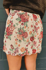 Apricot-toned jacquard floral mini skirt with buttoned front and scalloped hem