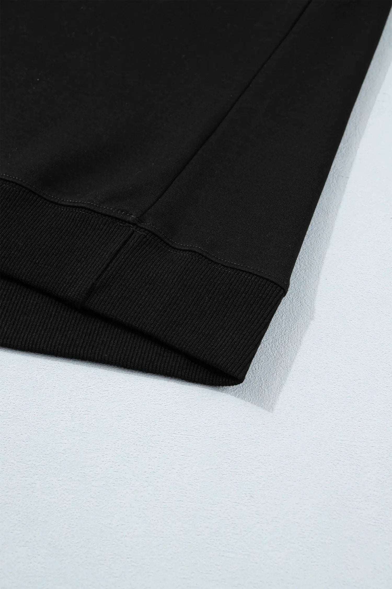 Effortless chic mom wearing a black short sleeve top with metal button details
