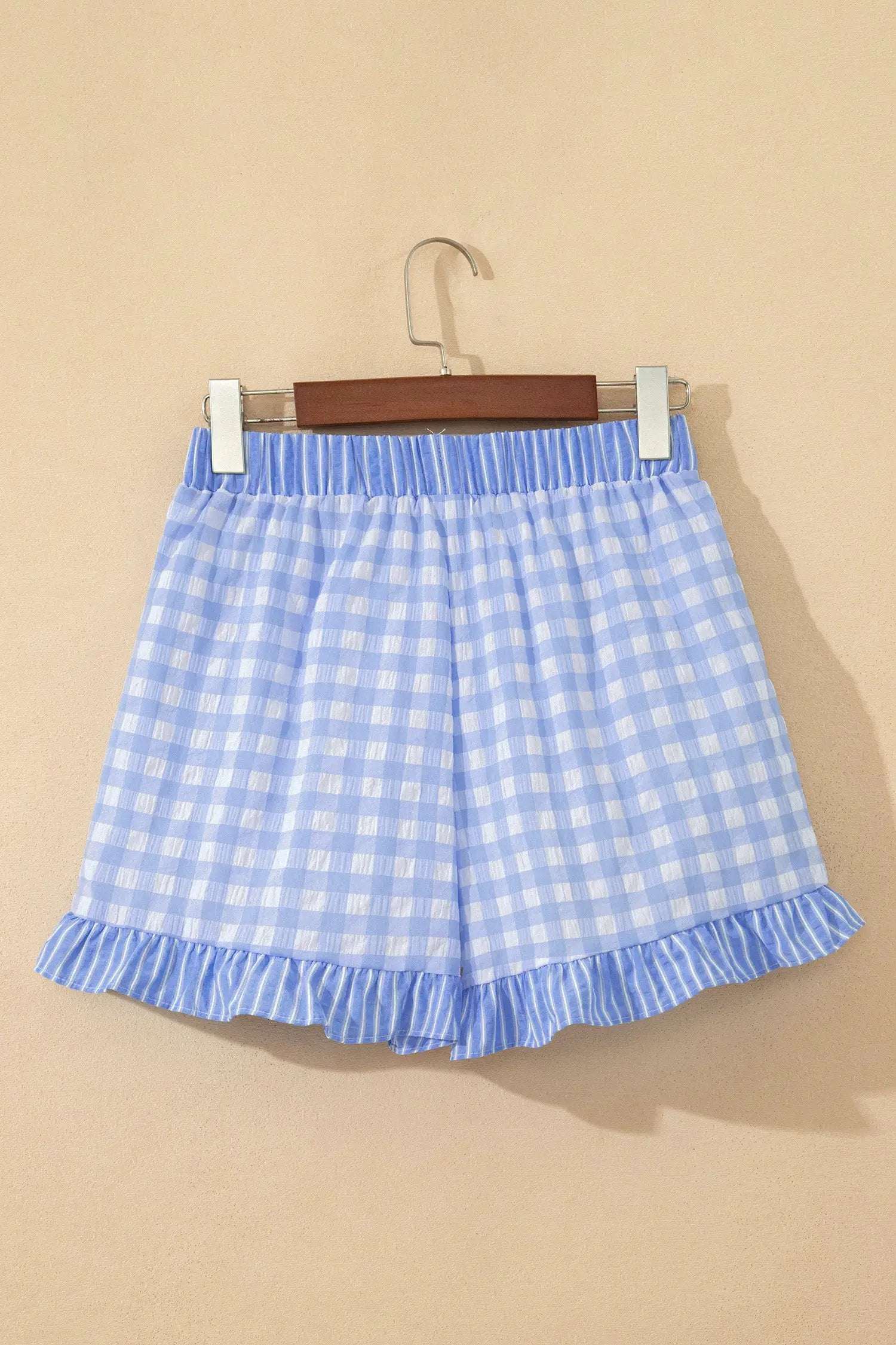Woman wearing gingham ruffle hem shorts with lace tie waist in casual weekend setting
