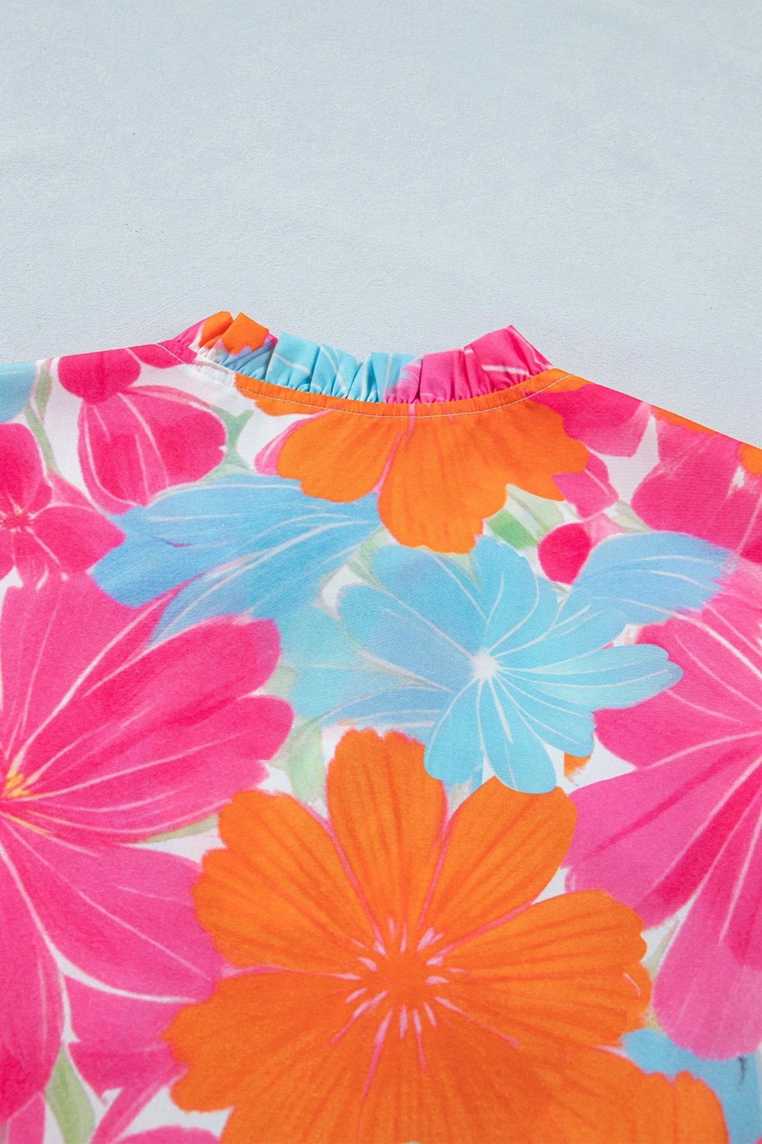 Multicolor vibrant floral tie-neck sleeveless blouse with ruffle trim