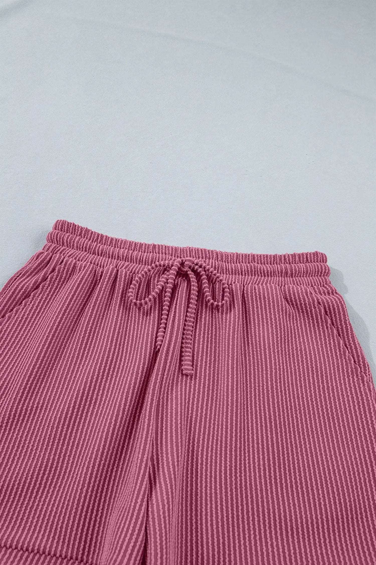 Woman wearing soft pink twisted ribbed two-piece set with loose tee and shorts