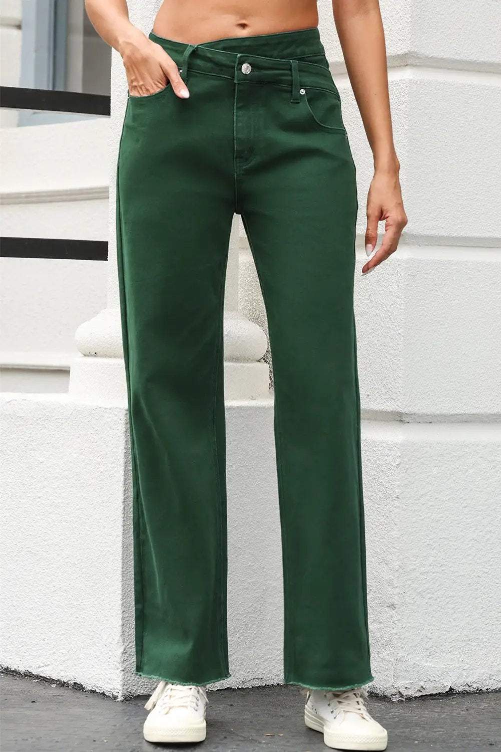 Woman wearing crossed waist raw-hem jeans with a relaxed straight-leg and western chic style