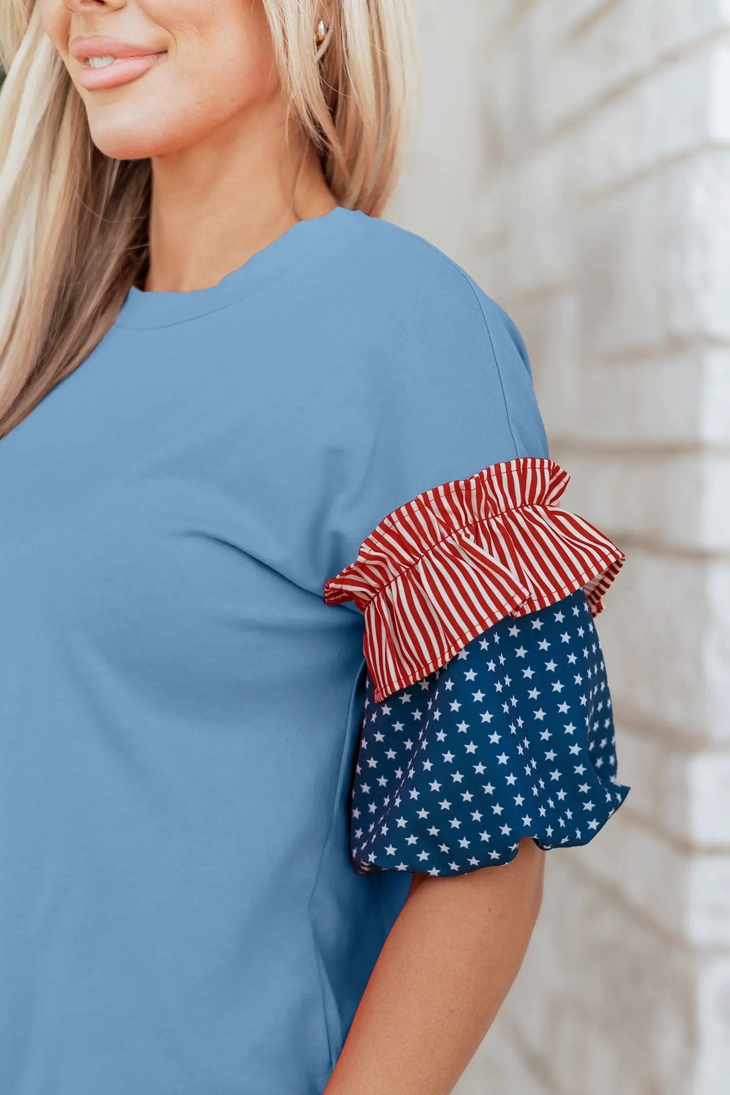 Patriotic puff sleeve top with fiery red stars stripes and American flag print on sky-blue fabric