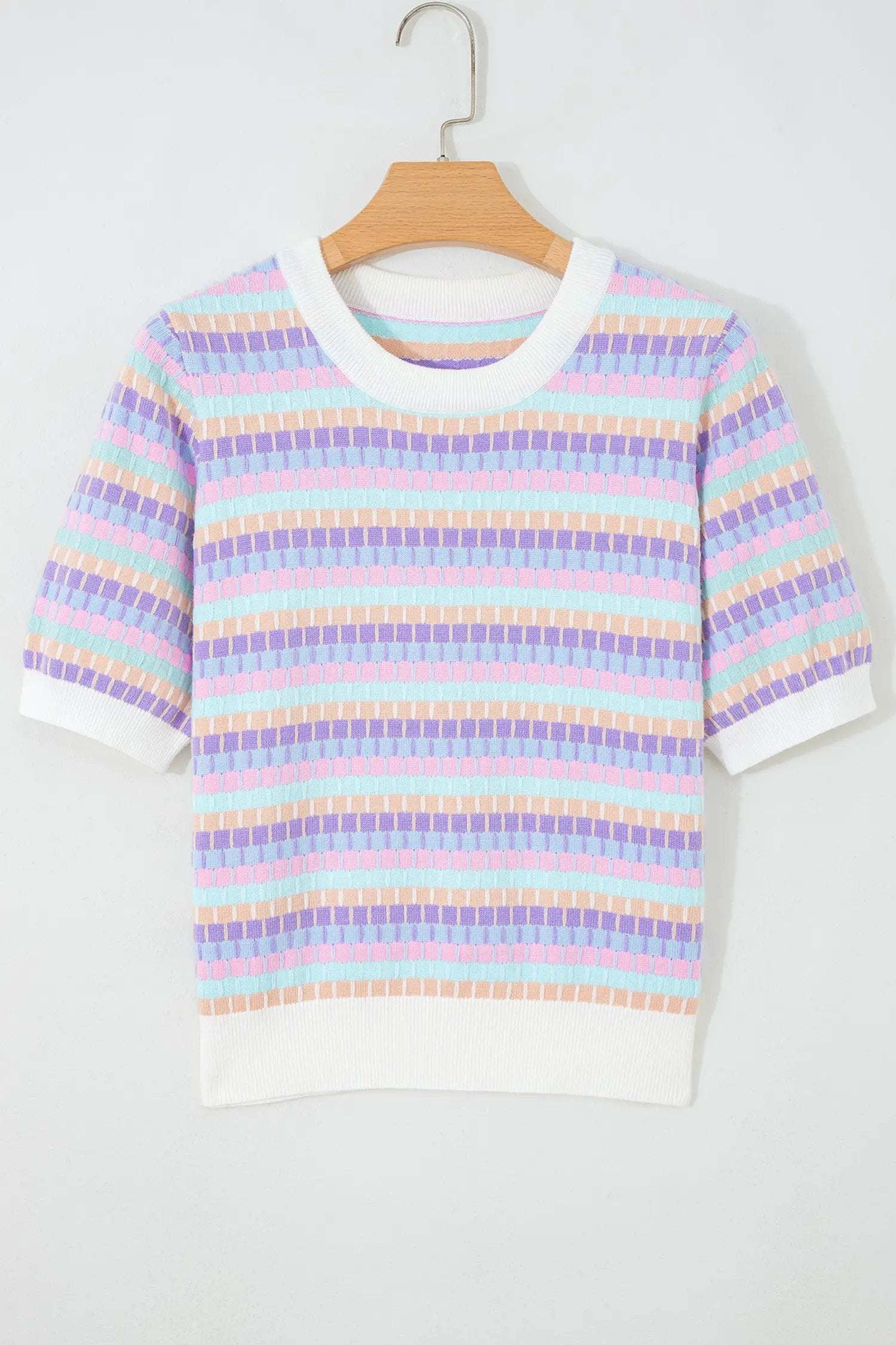 Woman wearing vibrant orange striped knit sweater with abstract stripes and fuchsia pink trim