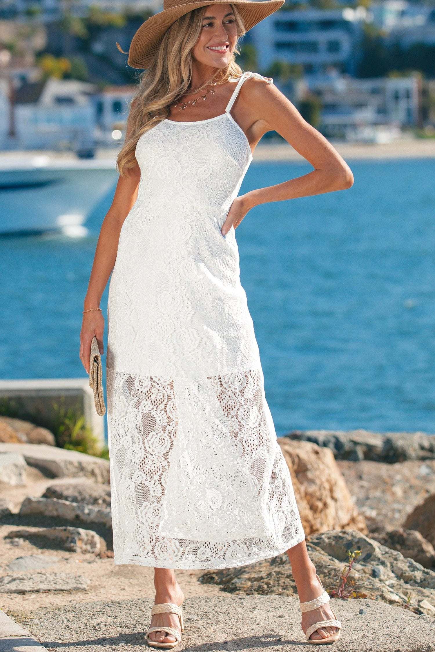 Woman wearing a floral lace overlay maxi dress with spaghetti straps in an airy, elegant A-line silhouette