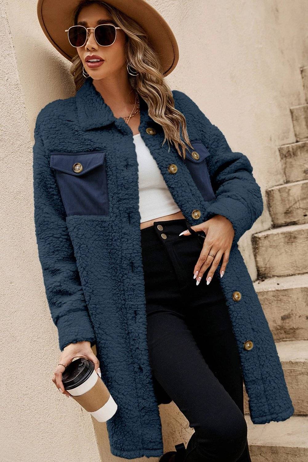 Woman wearing cozy teddy fleece coat with navy contrast flap pockets and single-breasted front
