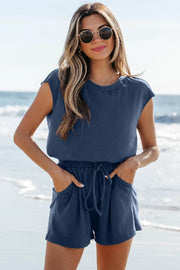 Blue knit open-back romper with drawstring waist and short sleeves, featuring side pockets for casual comfort