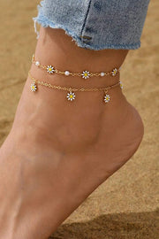 Delicate gold daisy and pearl chain anklet on ankle showcasing adjustable gold-tone links and subtle floral charm.