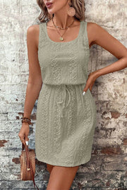 Woman wearing boho chic eyelet square-neck mini dress with drawstring waist outdoors