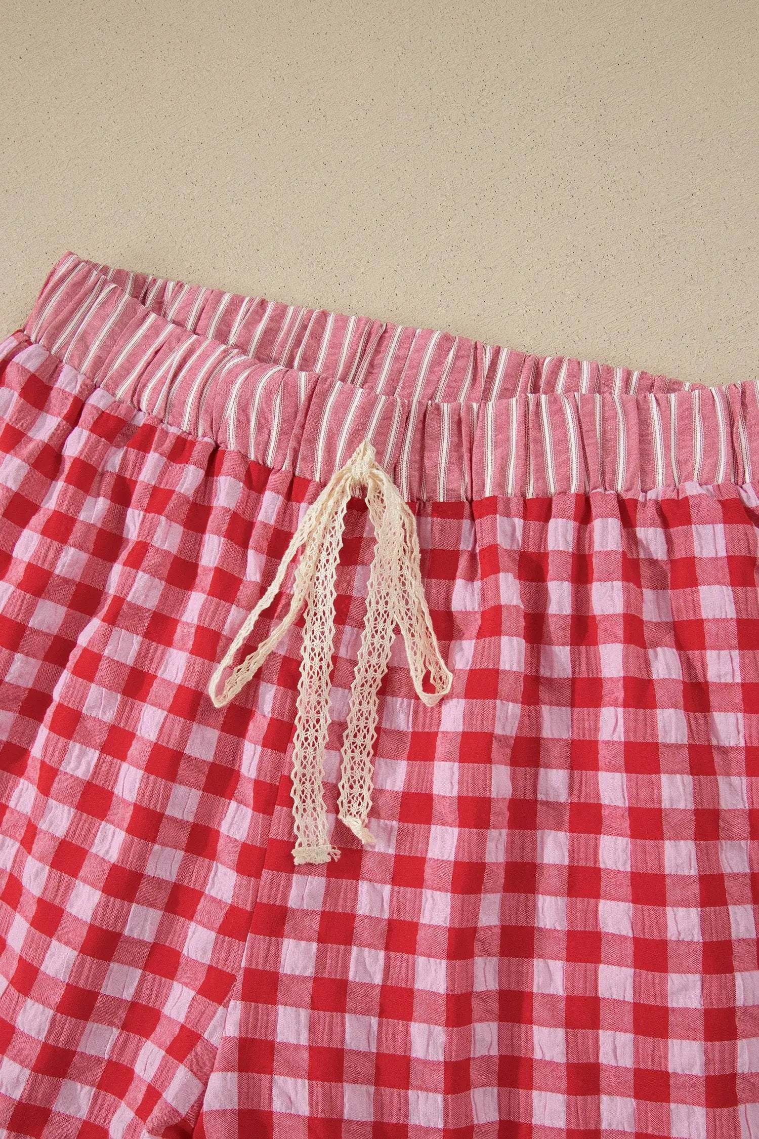 Woman wearing gingham ruffle hem shorts with lace tie waist outdoors on a sunny day