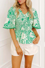 Green flirty floral smocked V-neck blouse with flutter sleeves and breathable fabric