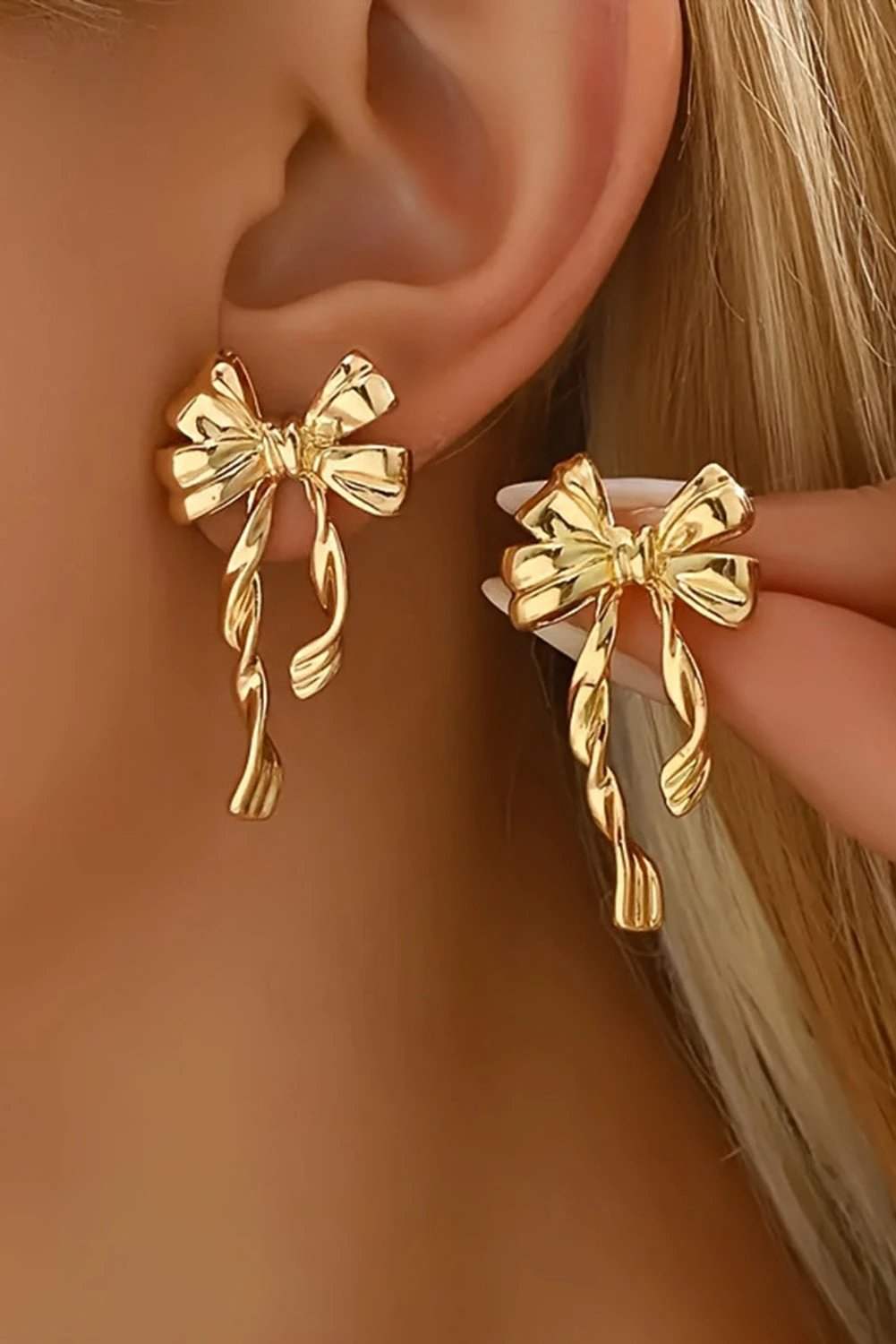 Gold bow knot plated alloy stud earrings with polished finish