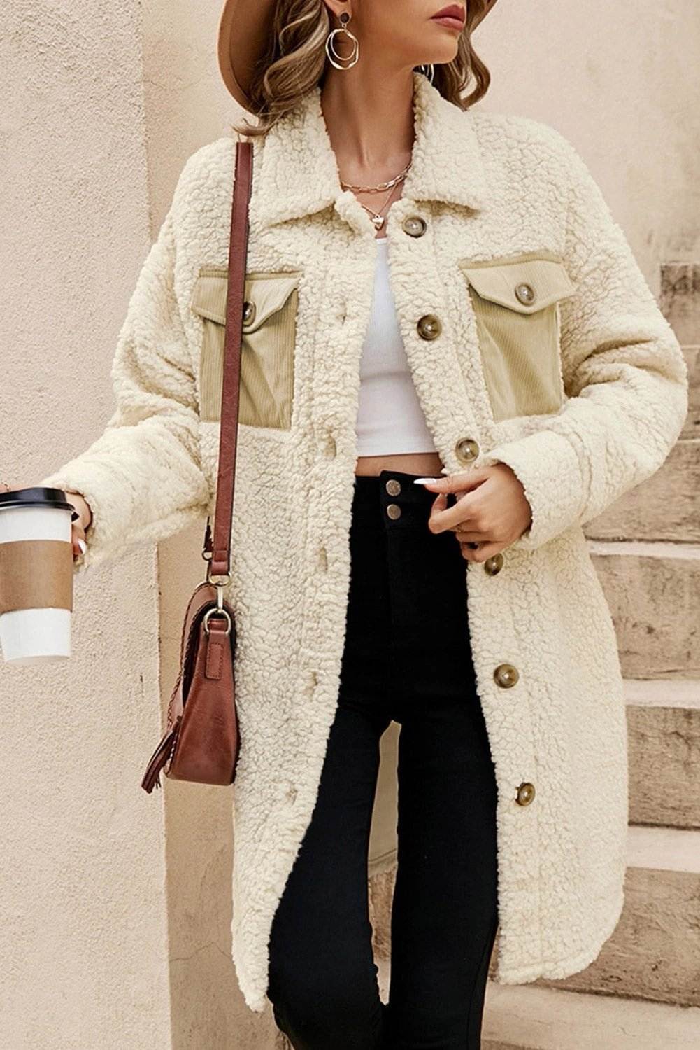Woman wearing a cozy teddy fleece coat with navy contrast flap pockets and single-breasted front