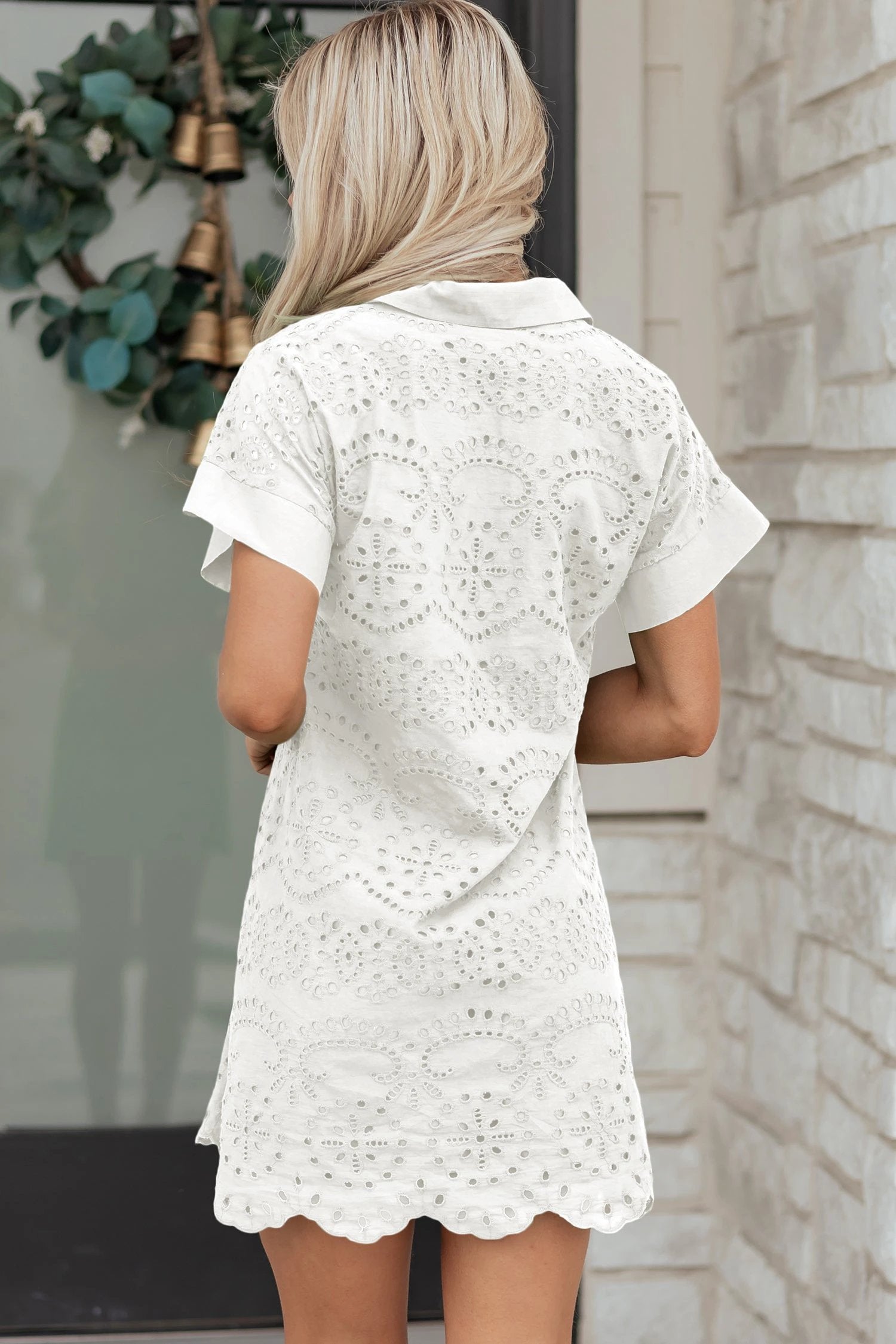 Woman wearing white solid color eyelet embroidered T shirt mini dress outdoors
