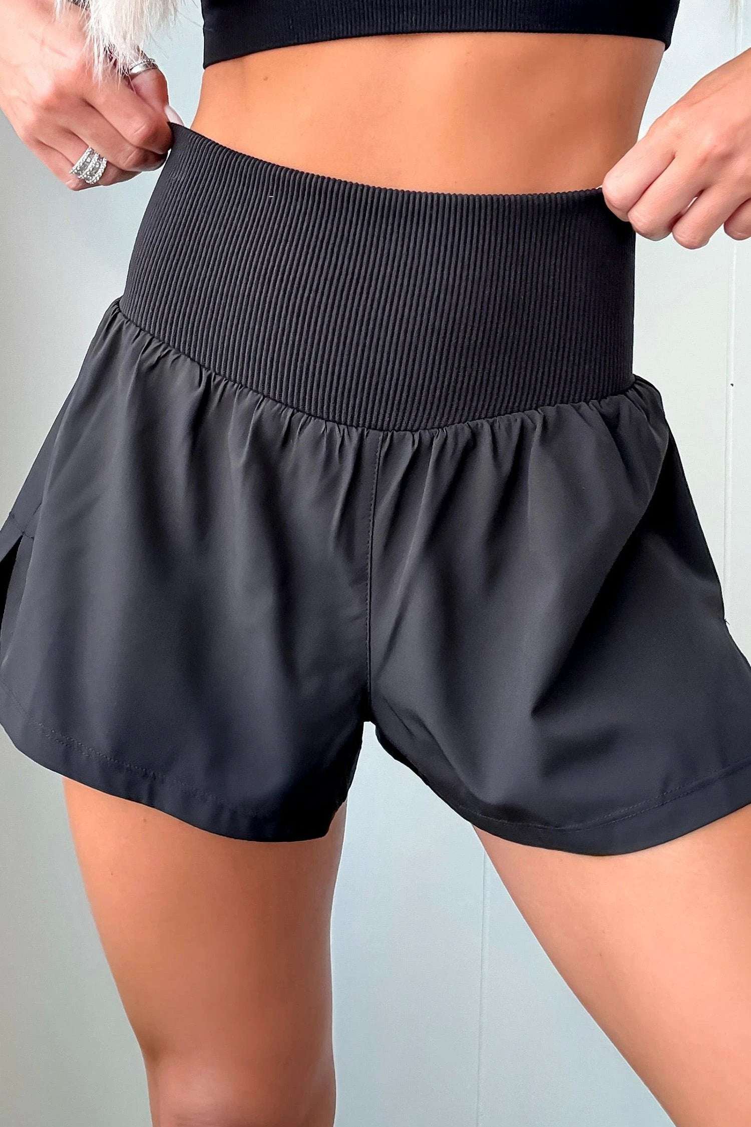 Woman wearing black ribbed high waist athletic shorts standing outdoors