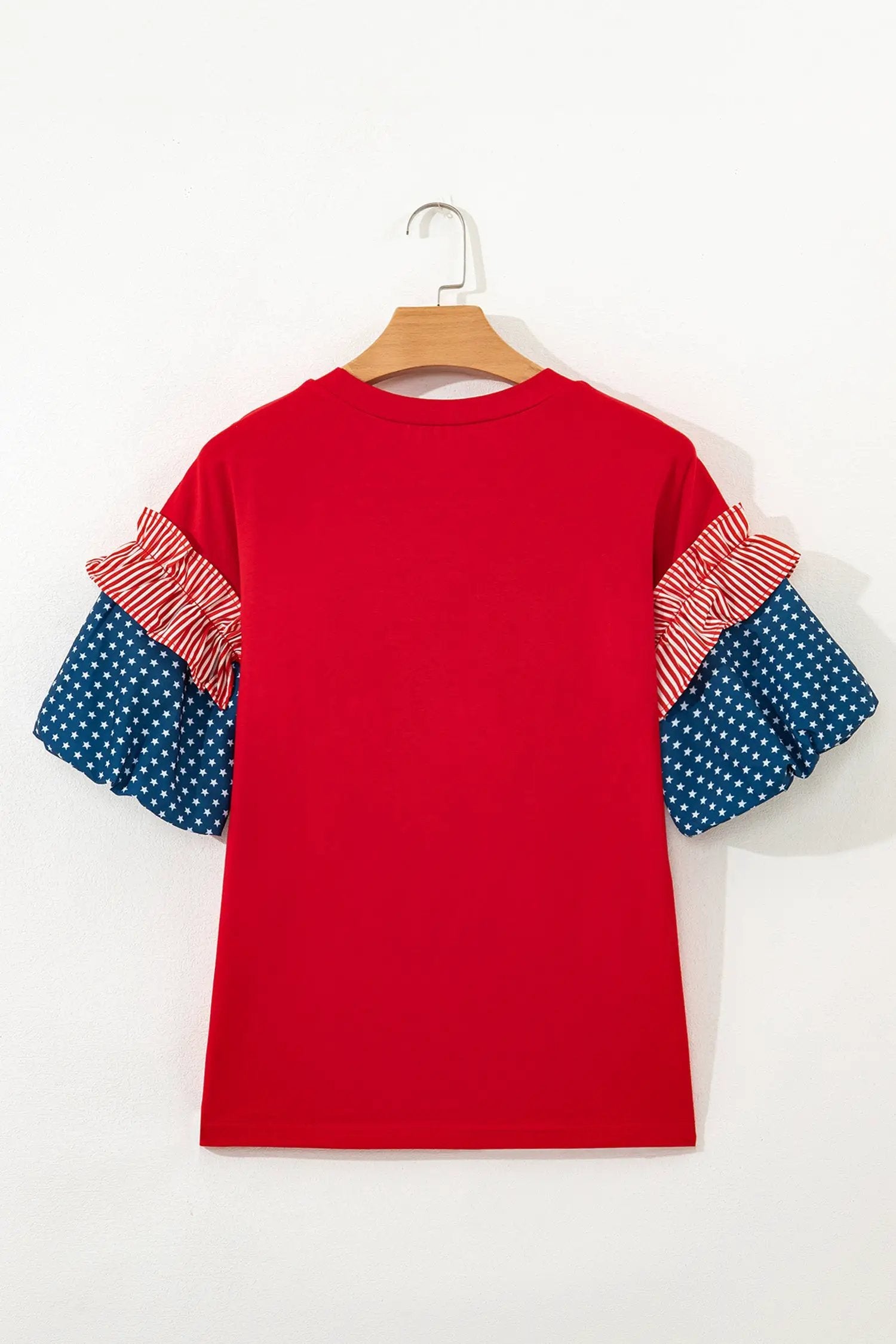 Woman wearing fiery red sequin USA lettering tee with blue star spliced sleeves
