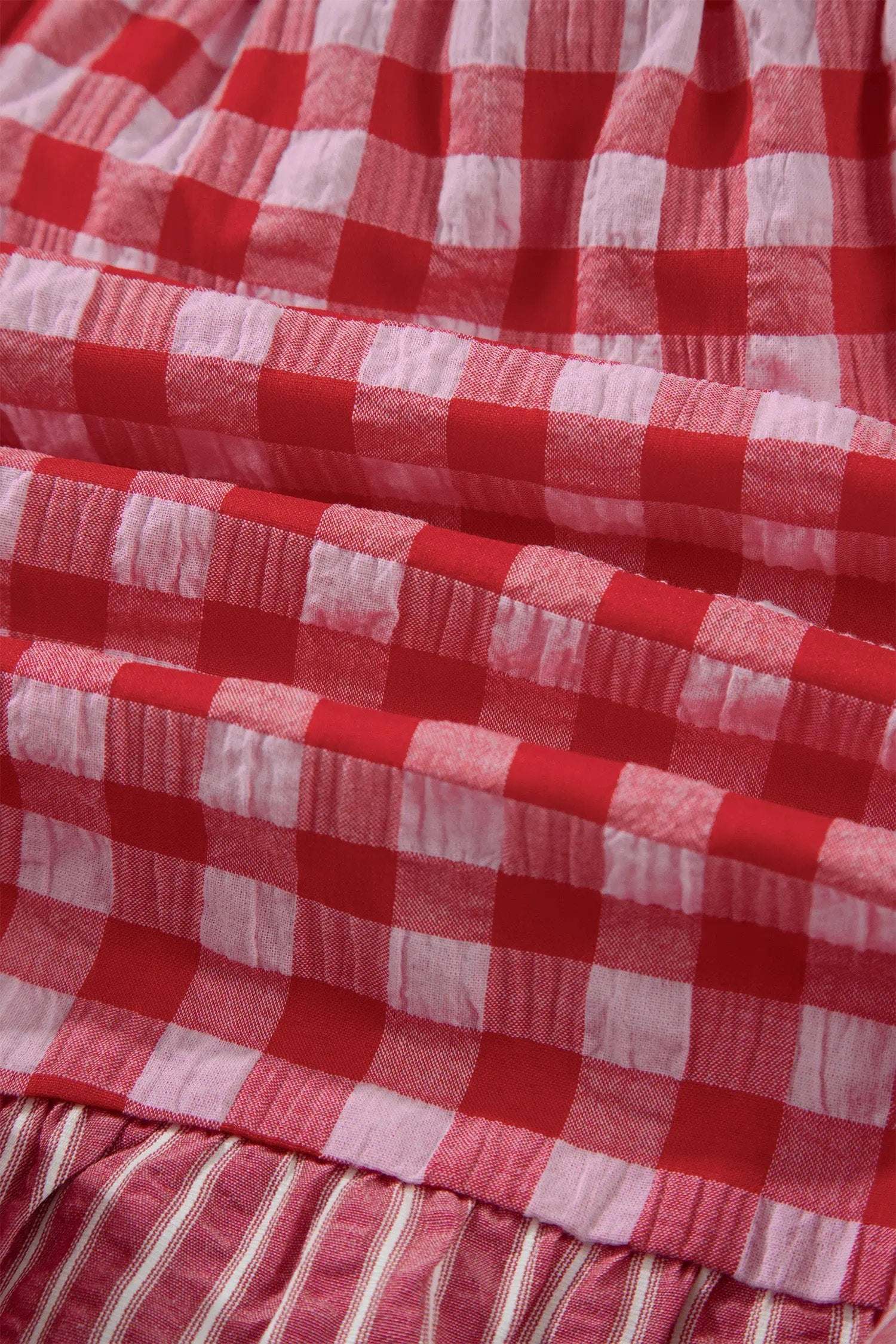 Woman wearing gingham ruffle hem shorts with lace tie waist detail