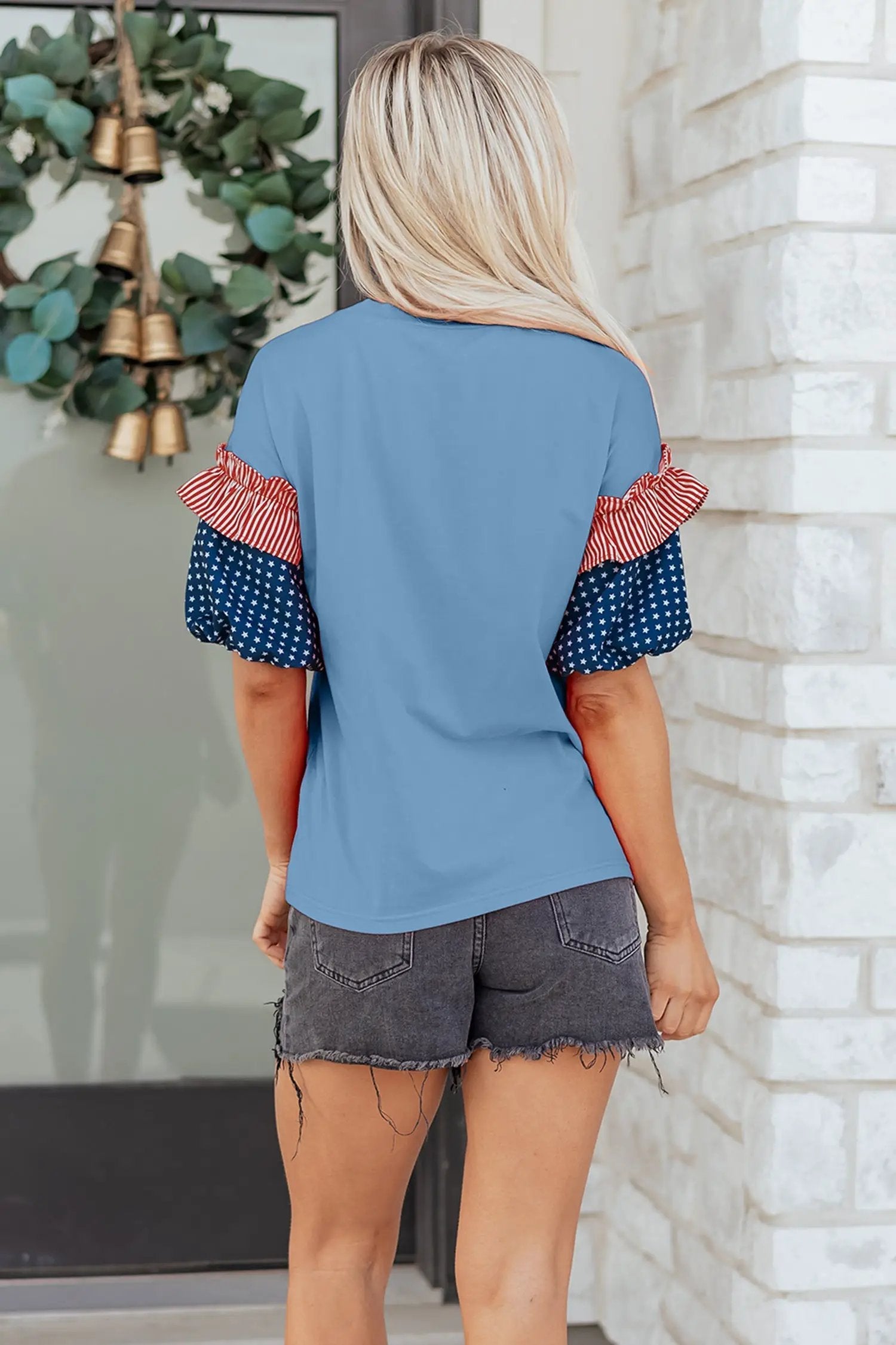 Patriotic puff sleeve top with fiery red stars stripes and American flag print on sky-blue fabric
