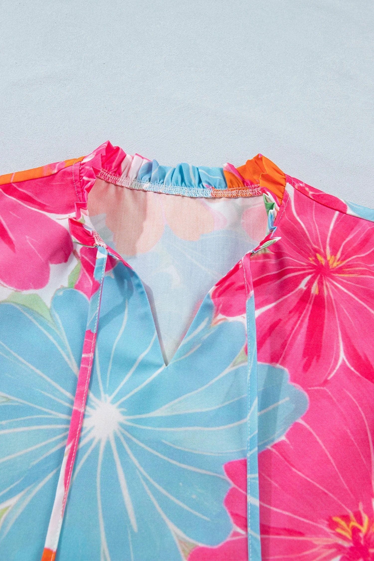 Multicolor vibrant floral tie-neck sleeveless blouse with ruffle trim