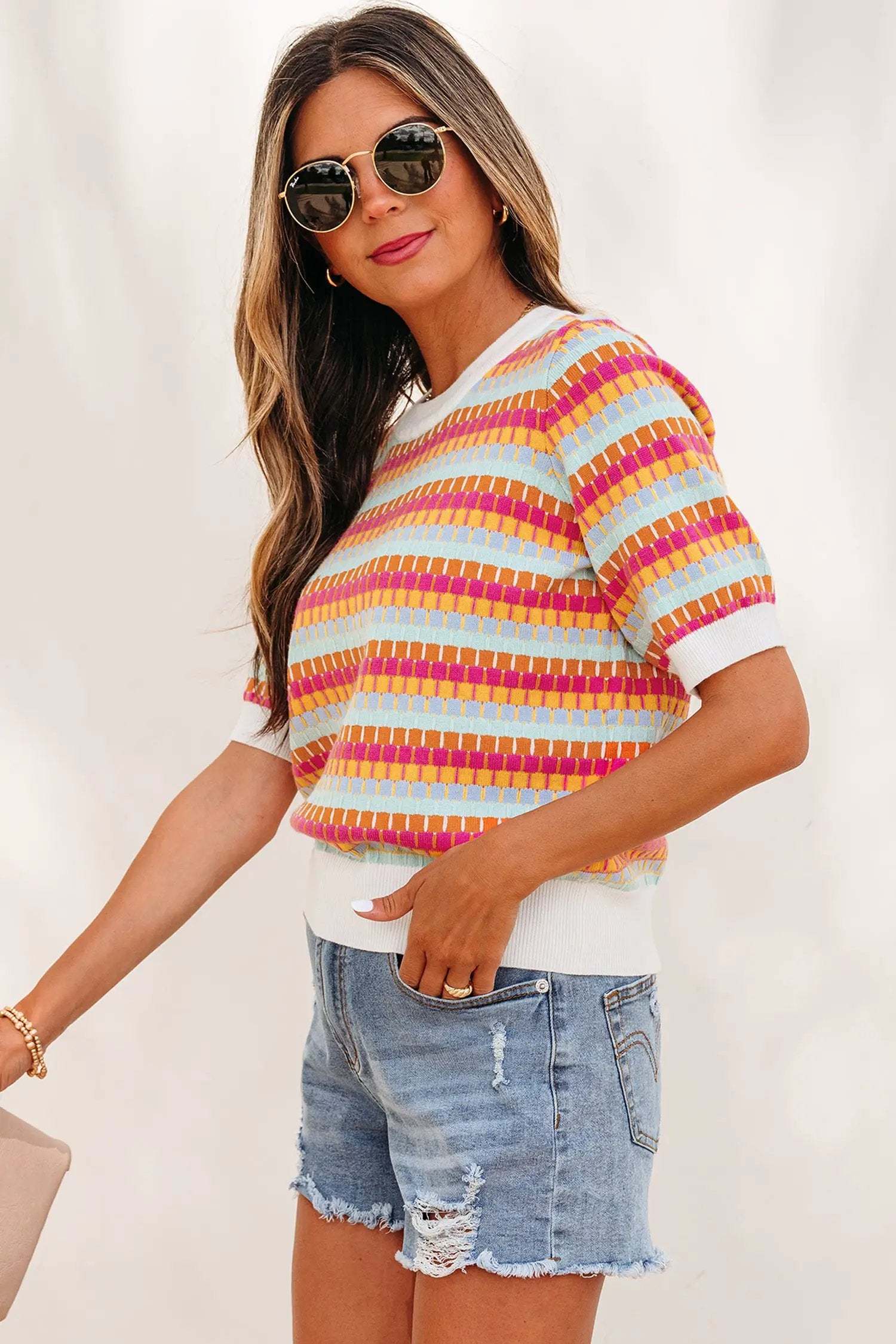 Orange striped knit sweater with abstract stripes and short sleeves on a model