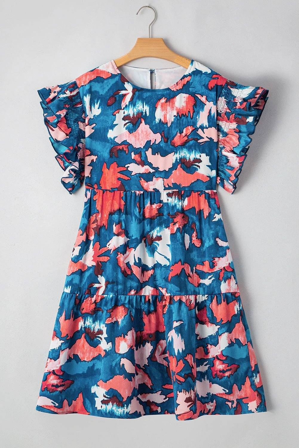 Plus size abstract print dress with shirred bodice, ruffled short sleeves, and tiered mini skirt