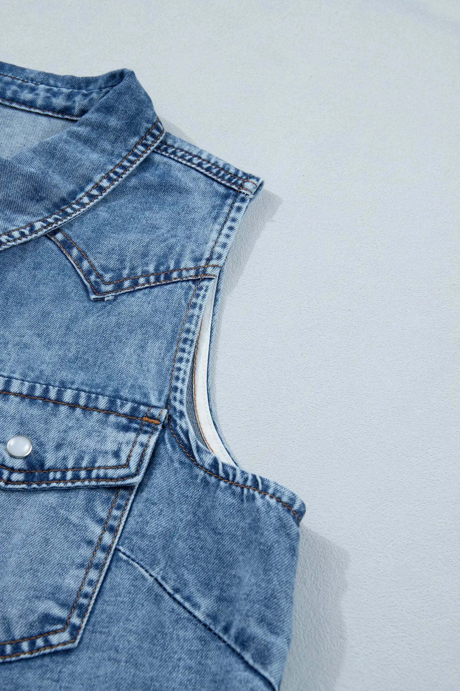 Sleeveless denim top with button-front and collar in Western chic style