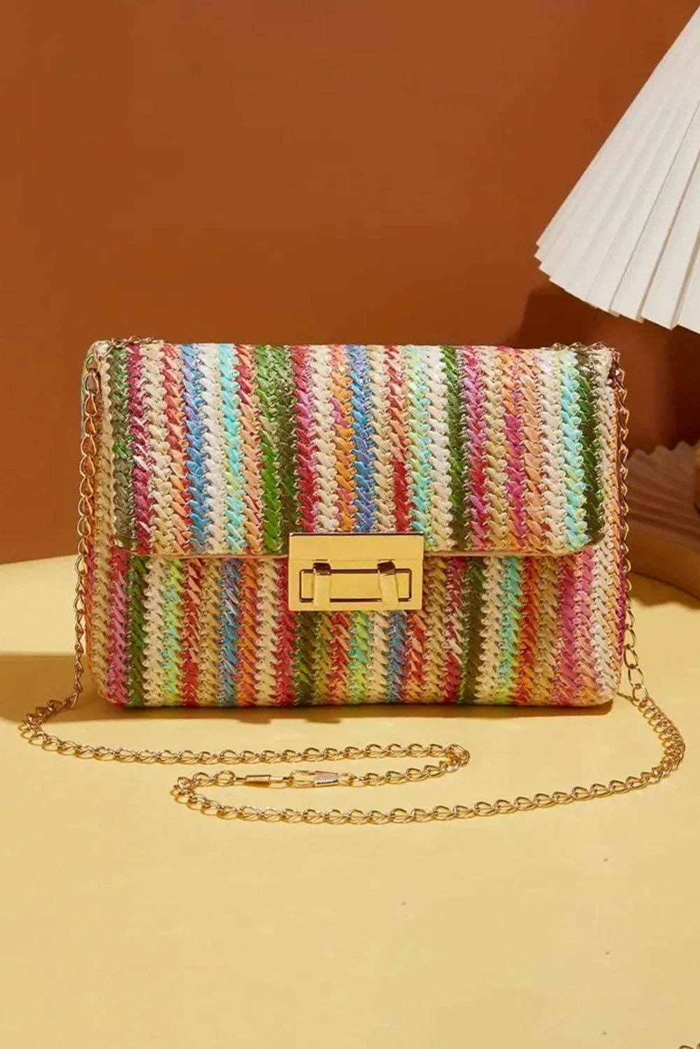 Strawberry pink bohemian woven shoulder bag with multicolor stripes and gold chain strap