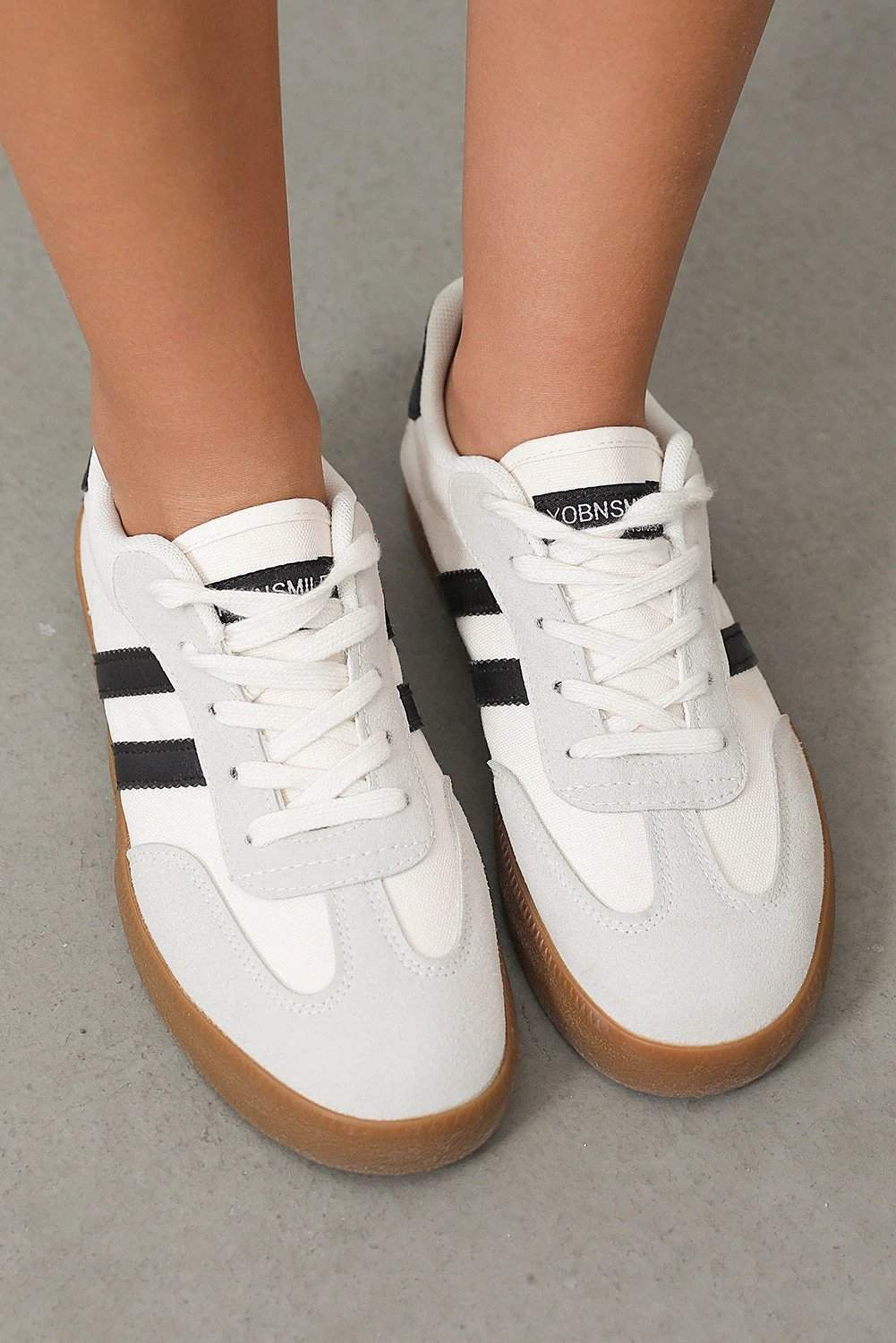 White striped lace-up flat sneakers with black accents and gum outsole for chic mom energy