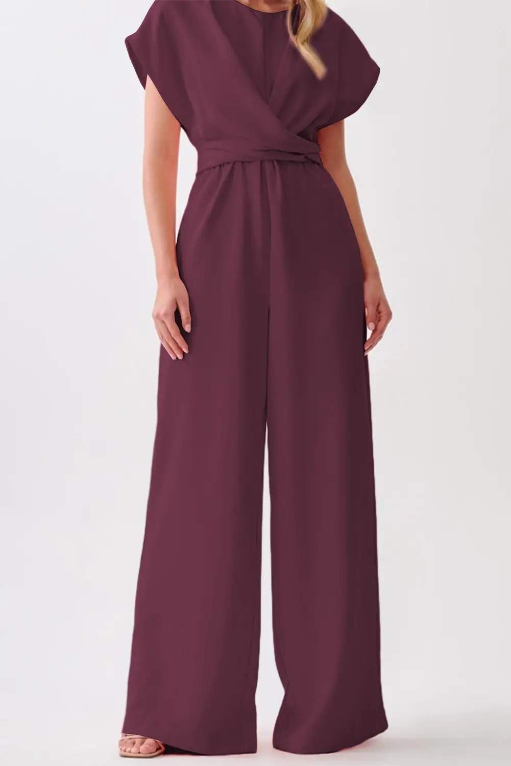 Woman wearing a rich wine knot-waist cap sleeve jumpsuit with a wide-leg silhouette