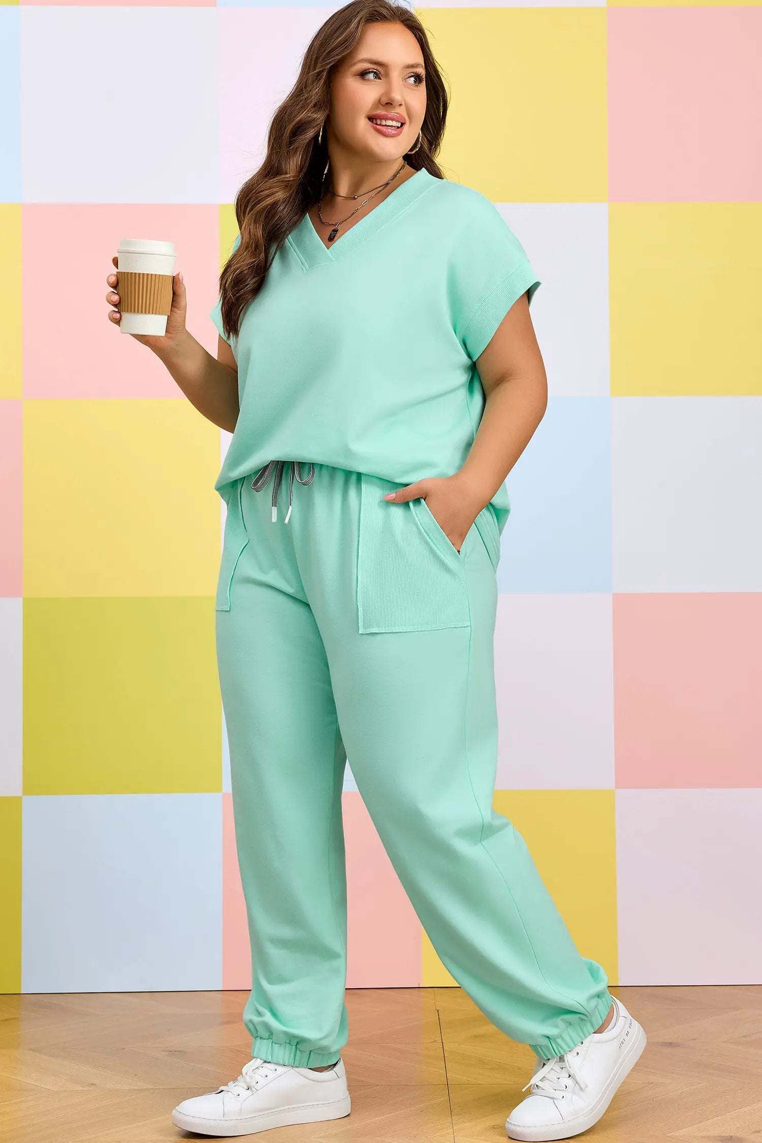 Plus size woman wearing relaxed V-neck tee and drawstring pants outfit set in casual lifestyle setting