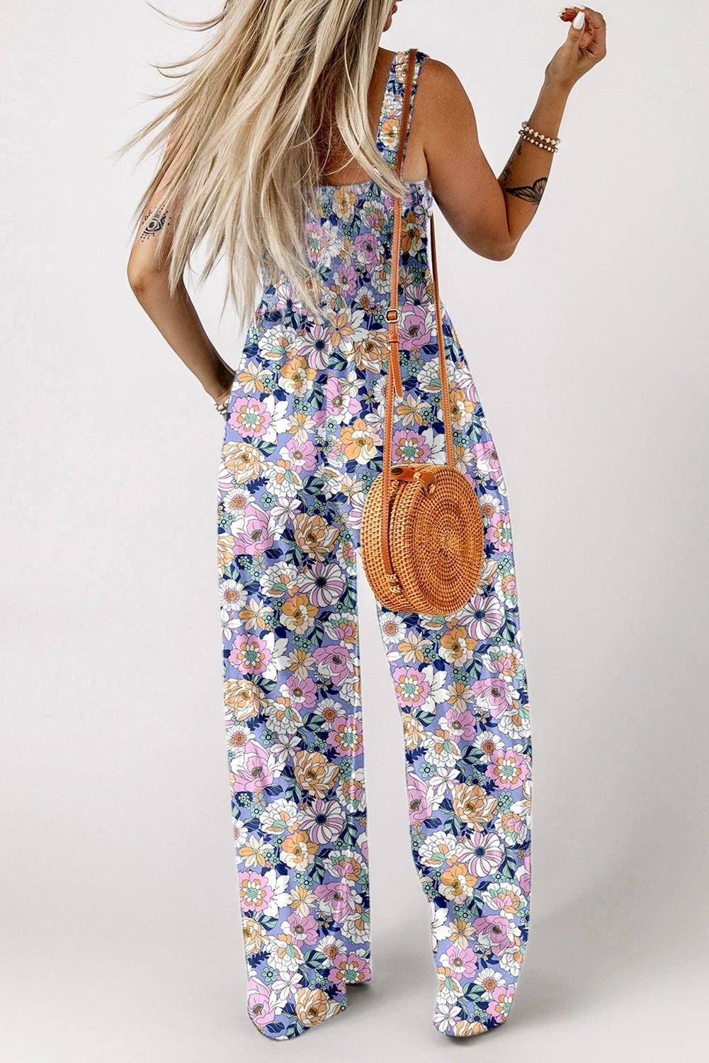 Boho Chic floral smocked square-neck jumpsuit with wide-leg silhouette on dark floral fabric