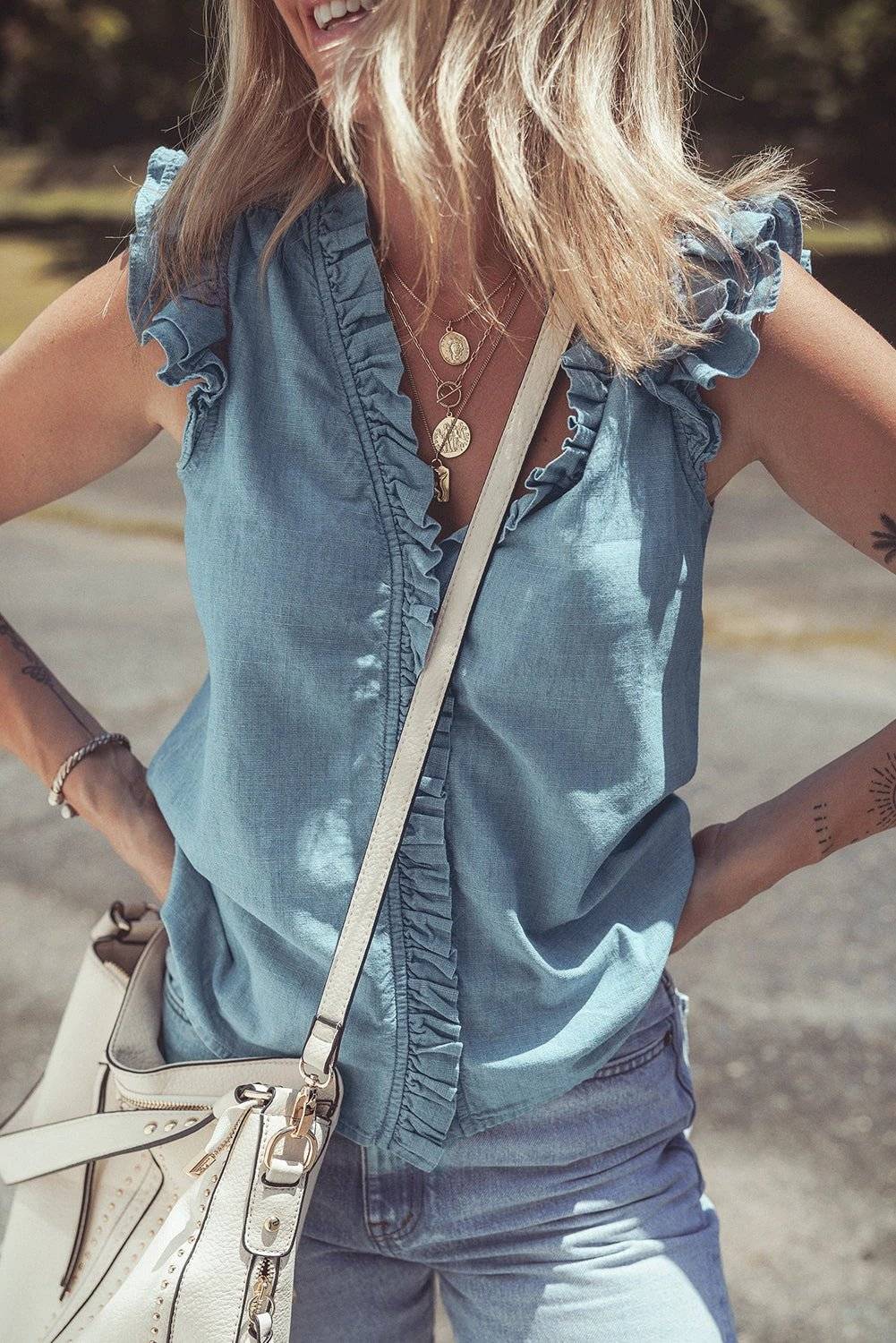 Woman wearing frill trim chambray tank top embodying chic mom energy