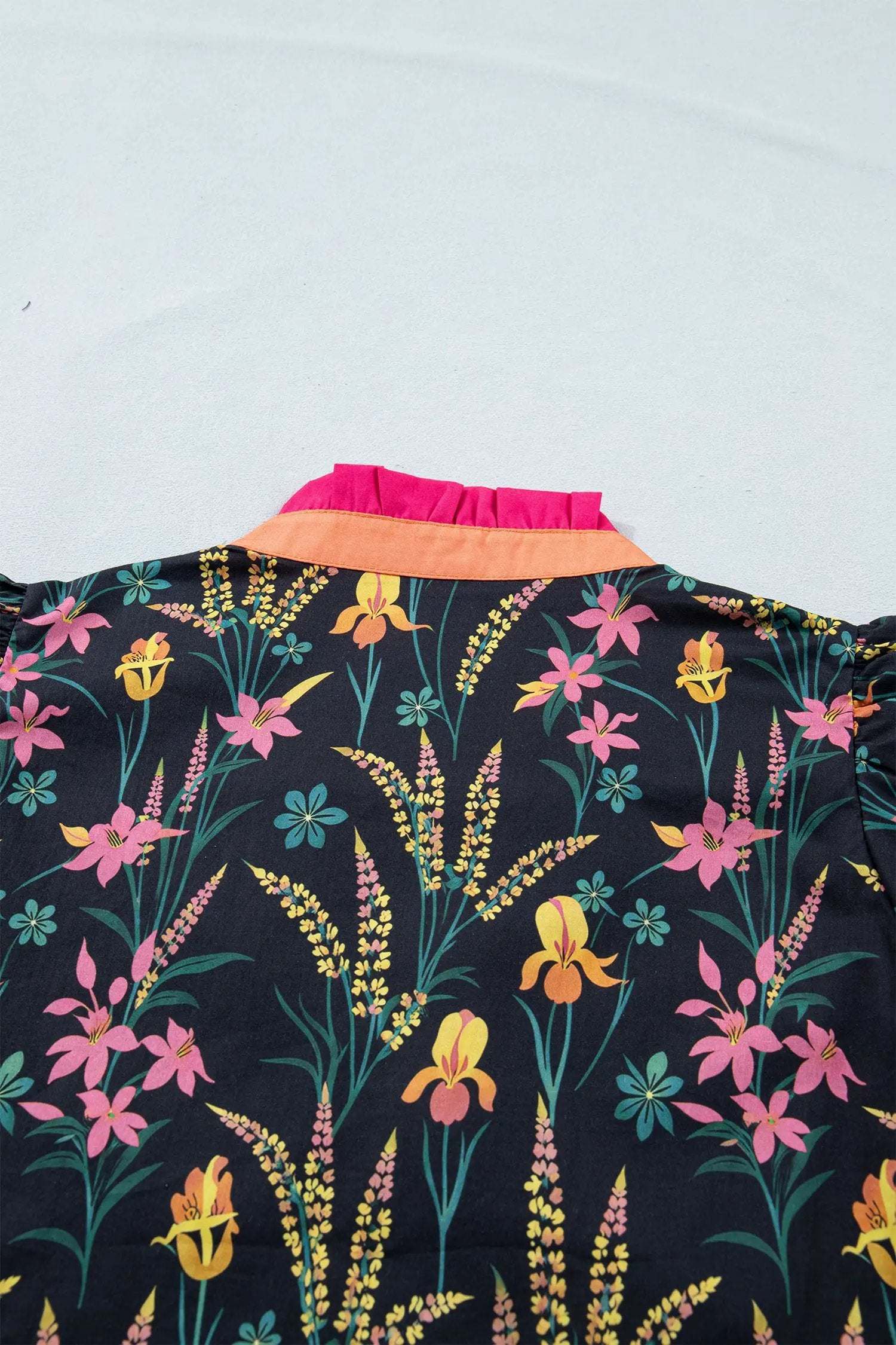 Black floral print tiered blouse with short ruffle sleeves and contrast trim neckline