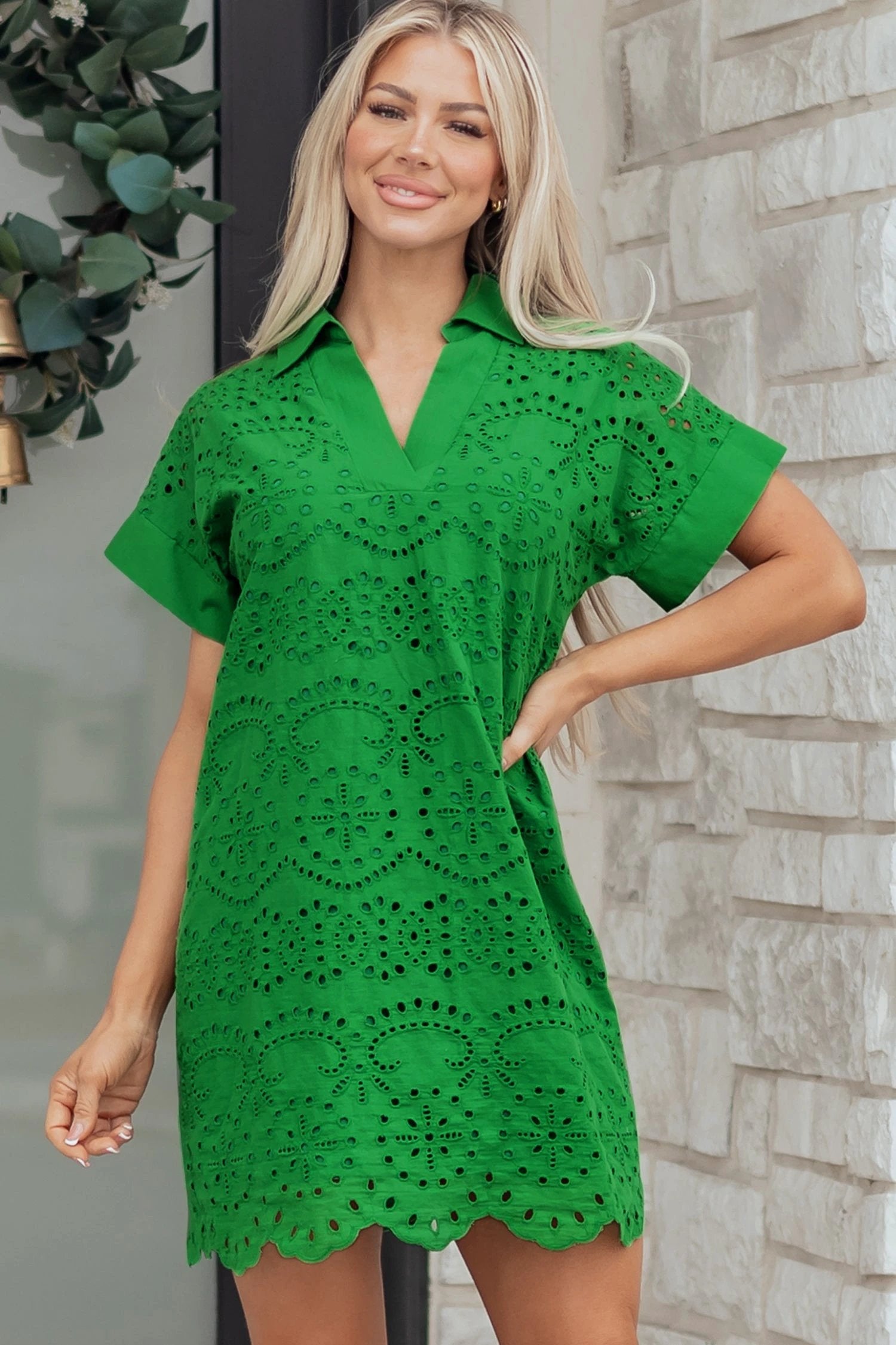 Woman wearing white solid color eyelet embroidered T shirt mini dress outdoors